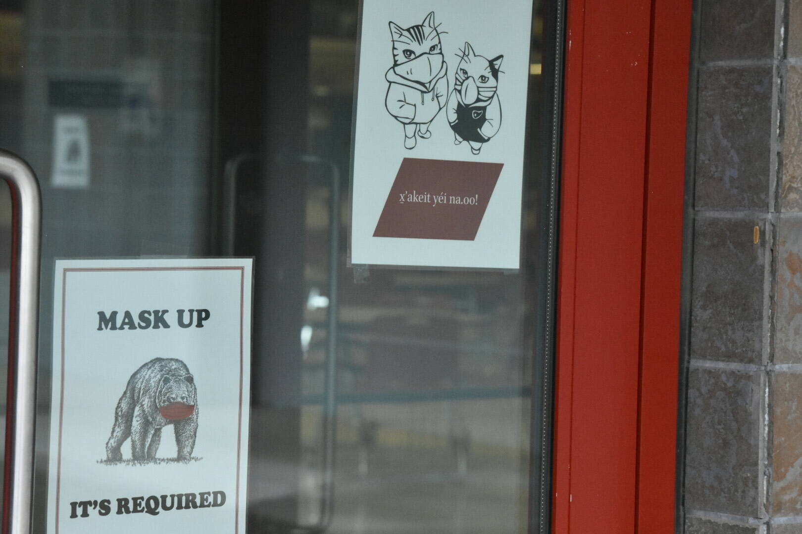 Signs on the doors at Juneau-Douglas High School: Yadaa.at Kalé remind those entering the building to wear masks. The Juneau School District Board of Education voted on Tuesday unanimously adopted additional COVID-19 mitigation measures.  (Peter Segall / Juneau Empire File)