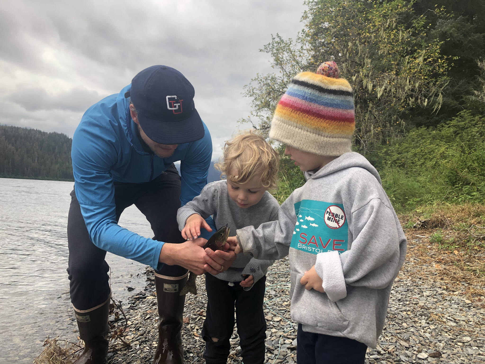 Sam and Silas Muse and Shiras Dihle inspect a cutthroat trout caught at Hasselborg Lake before returning it to the water. (Courtesy Photos / Mary Catharine Martin)