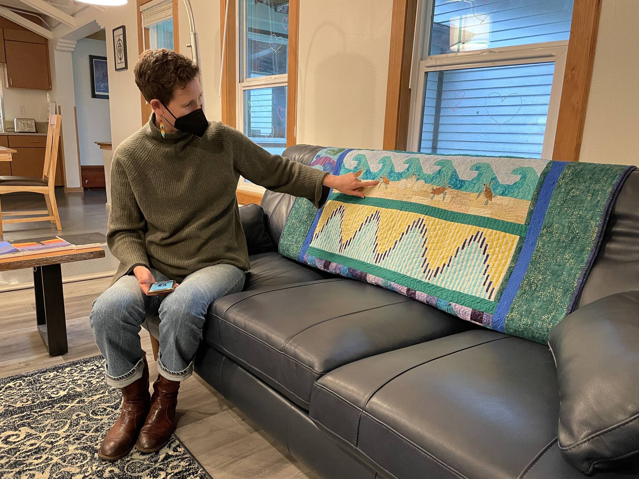 Zach Gordon Youth Center manager Jorden Nigro points out a quilt donated by a Monday night quilting group to Shéiyi X̱aat Hít, or Spruce Root House, Juneau’s new youth shelter, on Thursday, Sept. 23, 2021. (Michael S. Lockett / Juneau Empire)