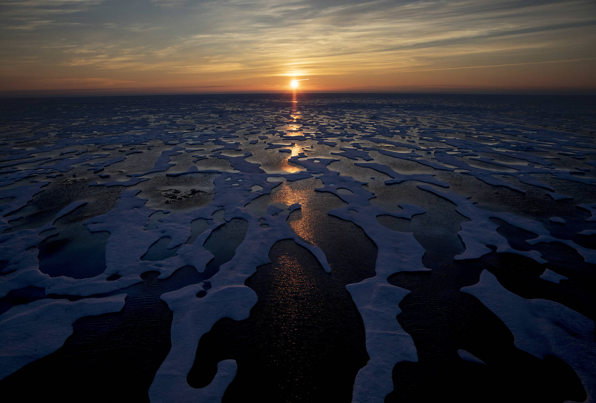 In this July 2017 photo, the midnight sun shines across sea ice along the Northwest Passage in the Canadian Arctic Archipelago. The Biden administration is stepping up its work to figure about what to do about the thawing Arctic, which is warming three times faster than the rest of the world. The White House said Friday, Sept. 24, 2021, that it is reactivating the Arctic Executive Steering Committee, which coordinates domestic regulations and works with other Arctic nations. It also is adding six new members to the U.S. Arctic Research Commission, including two indigenous Alaskans. (AP Photo / David Goldman)