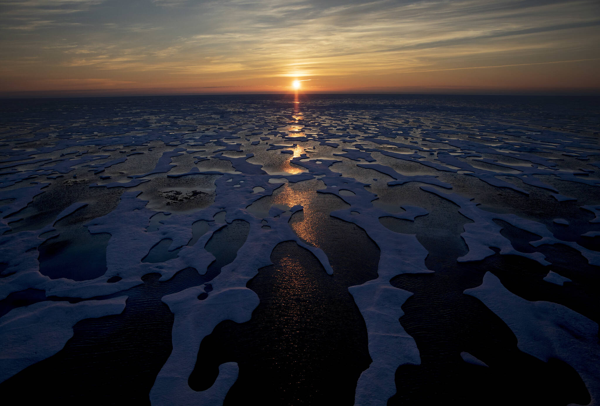 In this July 2017 photo, the midnight sun shines across sea ice along the Northwest Passage in the Canadian Arctic Archipelago. The Biden administration is stepping up its work to figure about what to do about the thawing Arctic, which is warming three times faster than the rest of the world. The White House said Friday, Sept. 24, 2021, that it is reactivating the Arctic Executive Steering Committee, which coordinates domestic regulations and works with other Arctic nations. It also is adding six new members to the U.S. Arctic Research Commission, including two indigenous Alaskans. (AP Photo / David Goldman)