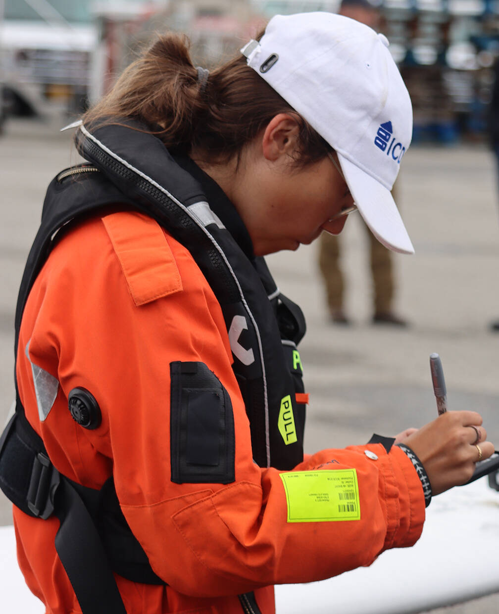 Zara Rutherford signs a phone case for a member of a small crowd that gathered Saturday to greet the young pilot who is attempting to fly around the world. (Ben Hohenstatt / Juneau Empire)