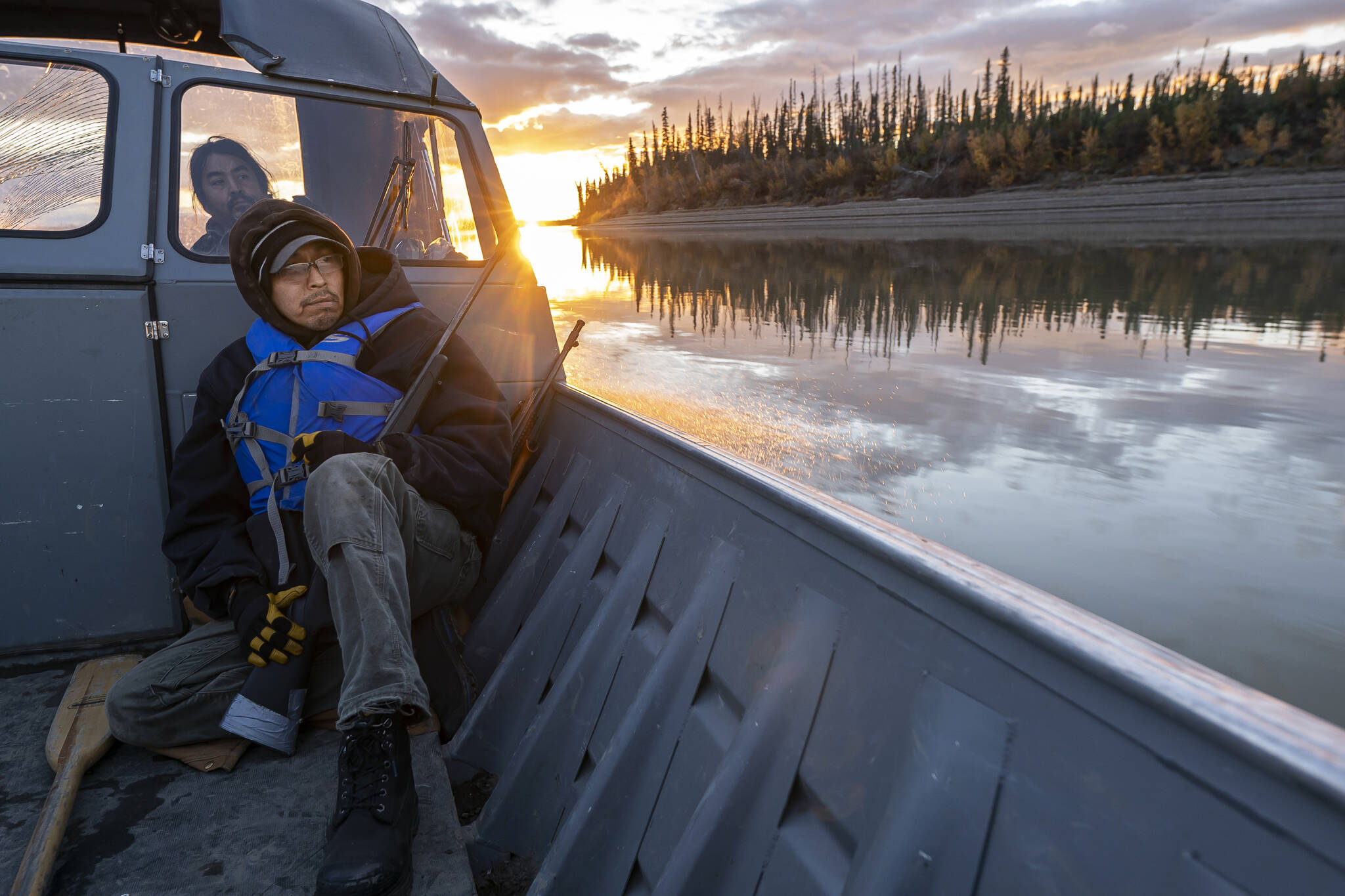 Michael Williams scans the shoreline for moose while traveling up the Yukon River on Tuesday, Sept. 14, 2021, near Stevens Village, Alaska. For the first time in memory, both king and chum salmon have dwindled to almost nothing and the state has banned salmon fishing on the Yukon. The remote communities that dot the river and live off its bounty are desperate and doubling down on moose and caribou hunts in the waning days of fall. (AP Photo/Nathan Howard)