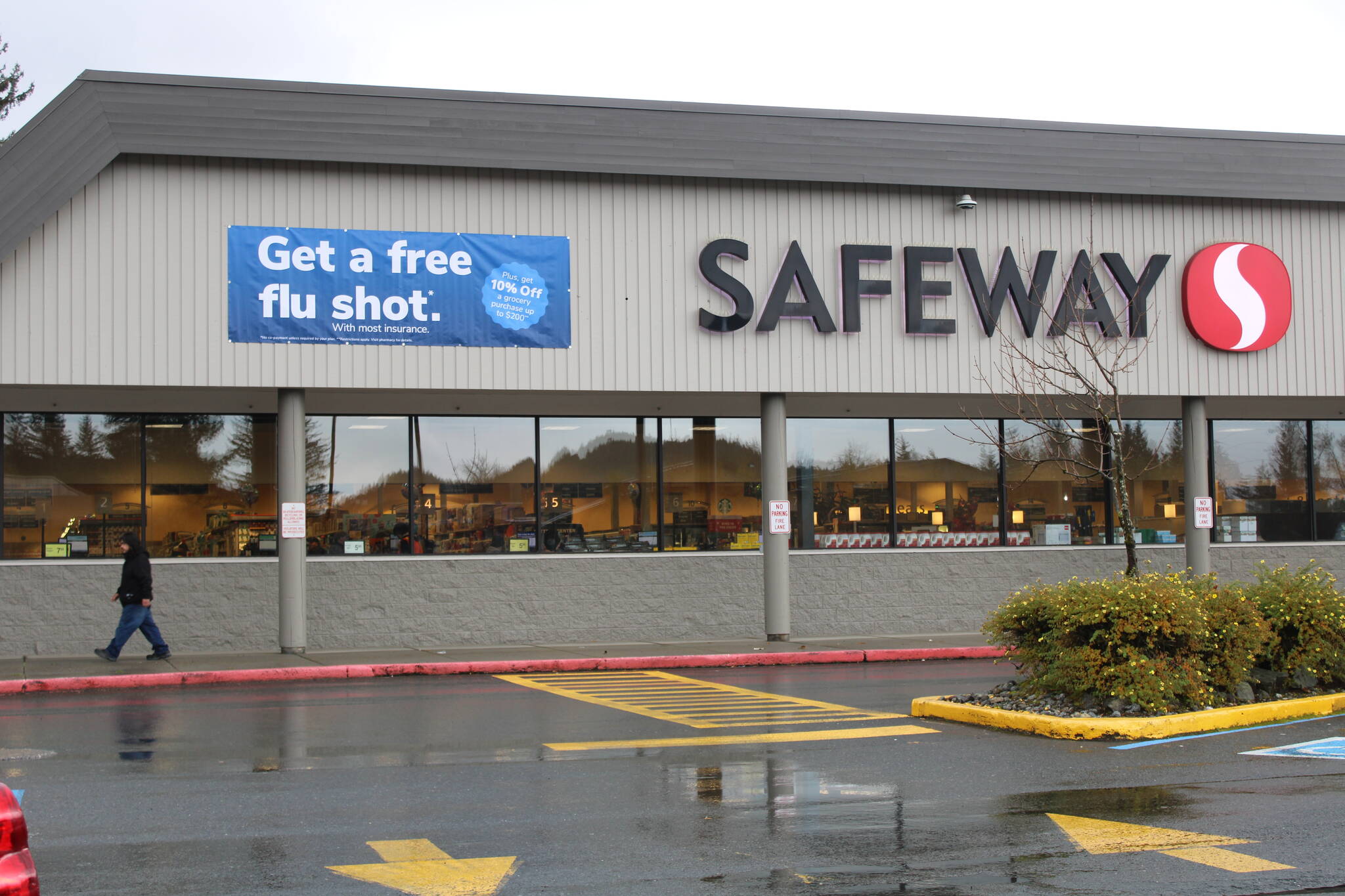 A sign outside of Safeway in the Mendenhall Valley advertises free flu shots with most insurance plans on Oct. 13. According to the sign, shoppers can earn a coupon for getting the shot at the store. Public health officials are urging all eligible Alaskans to get the shot by the end of the month to help make sure health care resources are available for COVID-19 patients. (Dana Zigmund/Juneau Empire)
