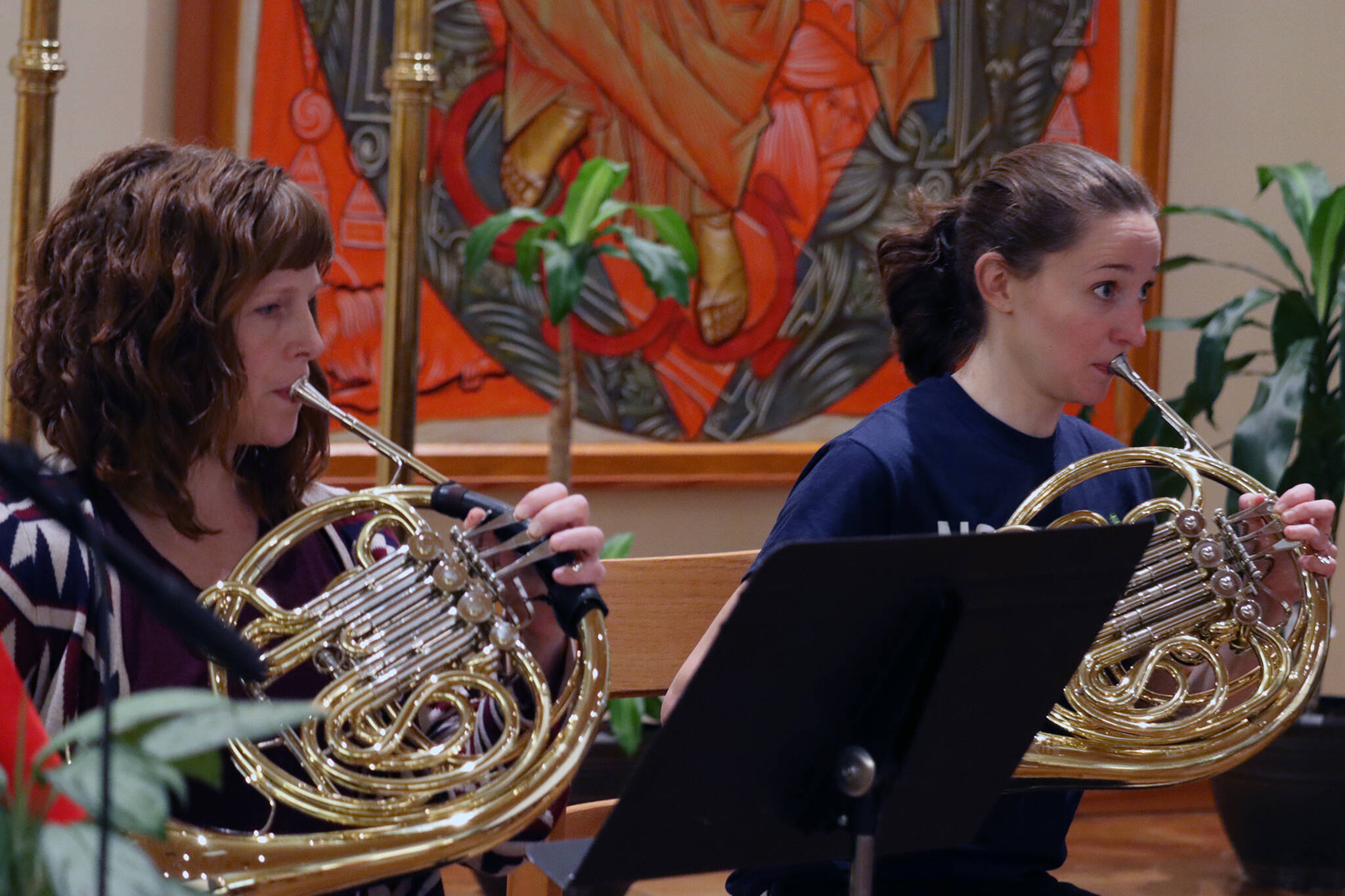 Jayne Berry and Taylor Young play french horns on Tuesday night during rehearsal for the Juneau Symphony’s return to in-person performances. (Ben Hohenstatt / Juneau Empire)