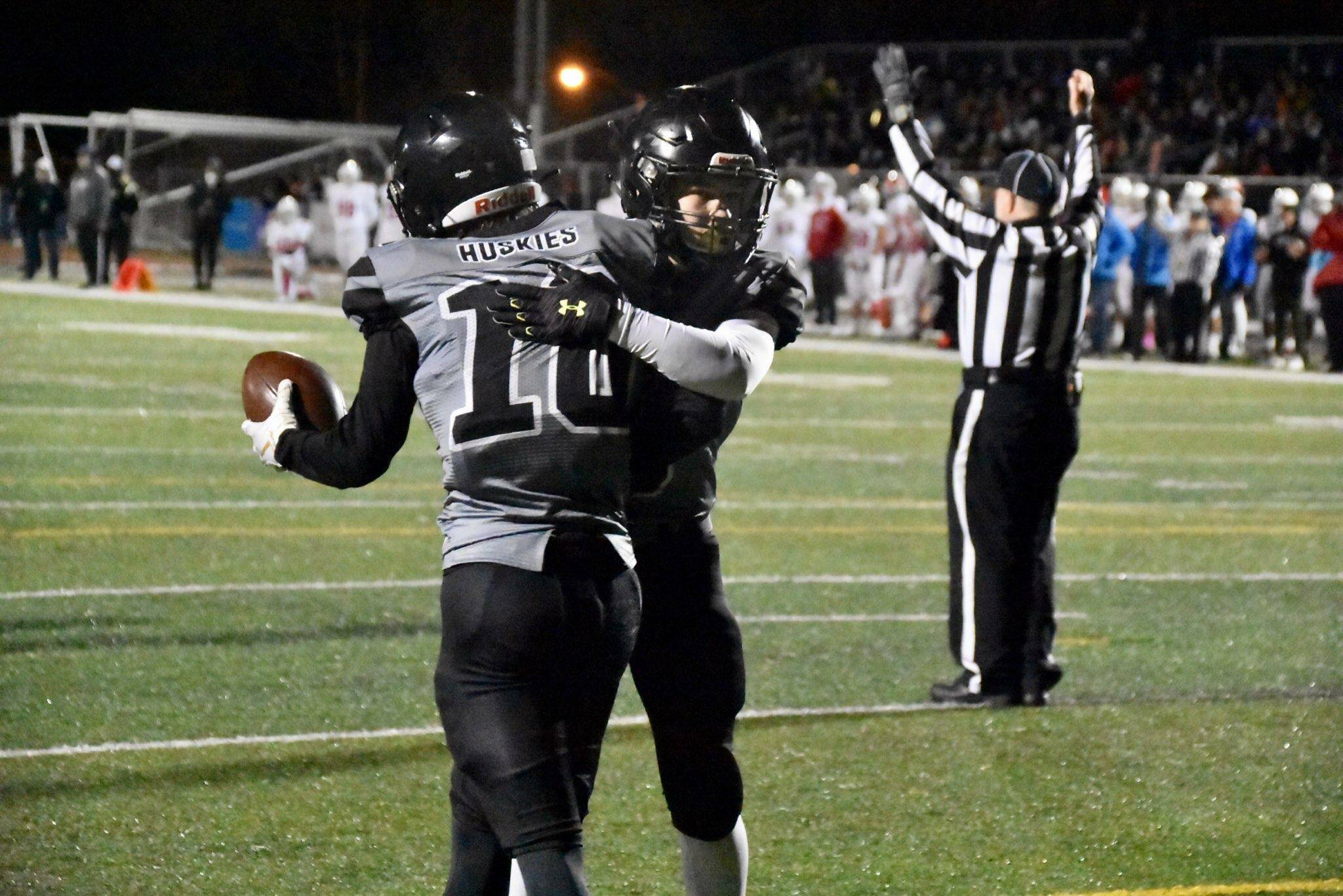 James Connally (10), a senior, and Payton Grant, a junior, embrace following a touchdown. Connally caught and threw for a touchdown in the Huskies’ 30-17 loss to Bettye Davis East Anchorage High School. (Courtesy Photo / Larry Schrader)