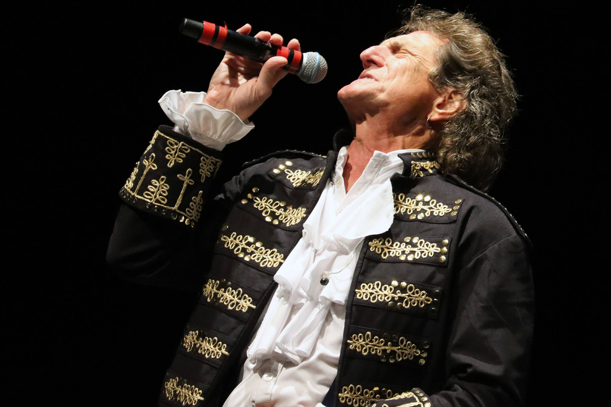 David Huizenga, lead vocalist for Paul Revere’s Raiders, rears his head back while singing during the band’s performance Tuesday night at Centennial Hall. (Ben Hohenstatt / Juneau Empire)