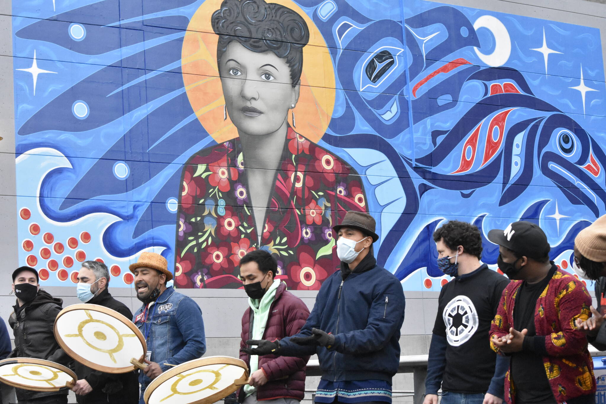 Artists of the inaugural Rock Aak’w Indigenous Music Festival gather beneath the mural of Elizabeth Peratrovich on the Juneau waterfront on Friday, Nov. 5, 2021. This year the ceremony was all virtual, but organizers wanted to open the festival in person. (Peter Segall / Juneau Empire)