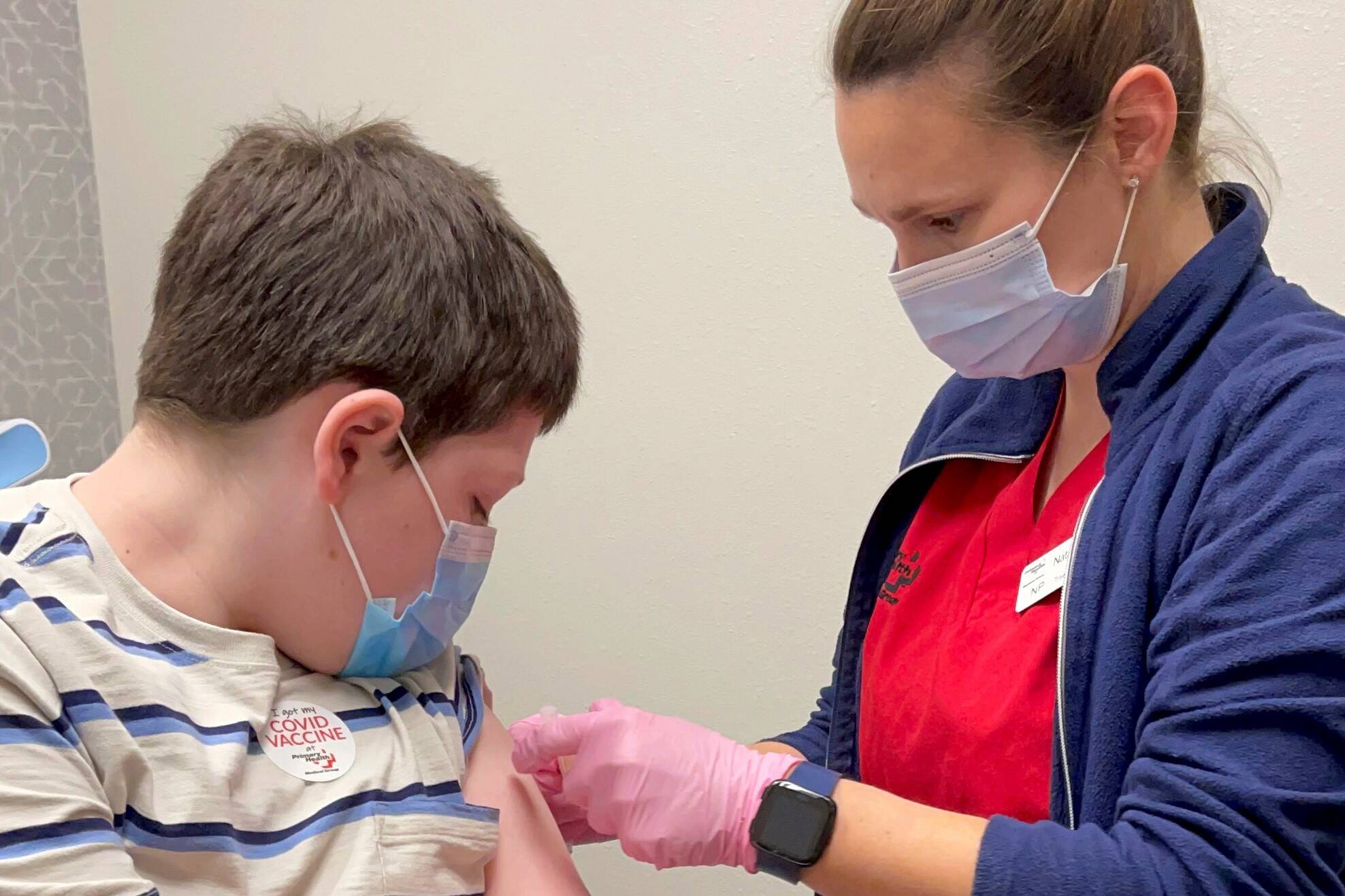 In this Wednesday, Nov. 3, 2021, photo provided by Primary Health Medical Group, Ben Weiss, 10, gets a COVID-19 vaccine at Primary Health Medical Group in Meridian, Idaho. (Tracy Morris/Primary Health Medical Group via AP)