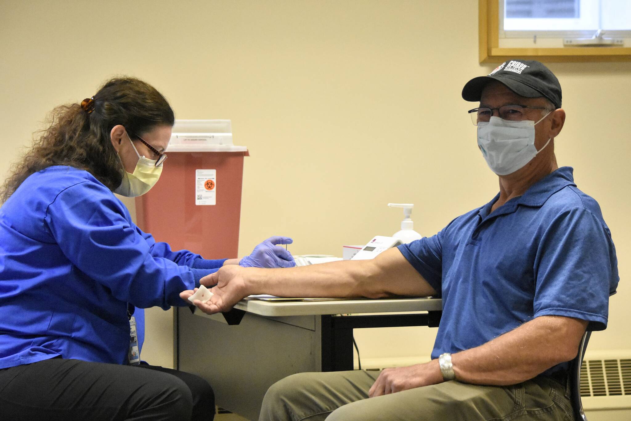 Fritz Moser, 63, waits while registered nurse Lori Higgins test his blood sample for glucose and cholesterol levels at a free screening clinic on Saturday, Nov. 6, 2021, at Bartlett Regional Hospital. The hospital used to hold regular health clinics to stress the importance of preventive health care but those had to close with the COVID-19 pandemic. (Peter Segall / Juneau Empire)