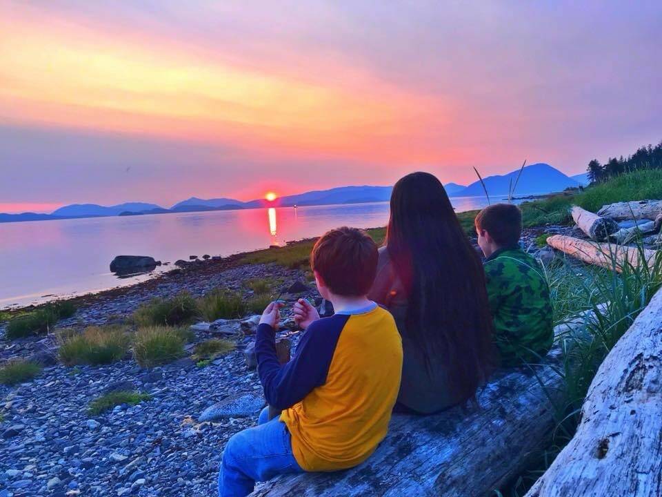 Yeilk’ Vivian Mork sits watching a sunset with nephews Timothy and Jackson Person, Wrangell. (Vivian Faith Prescott / For the Capital City Weekly)