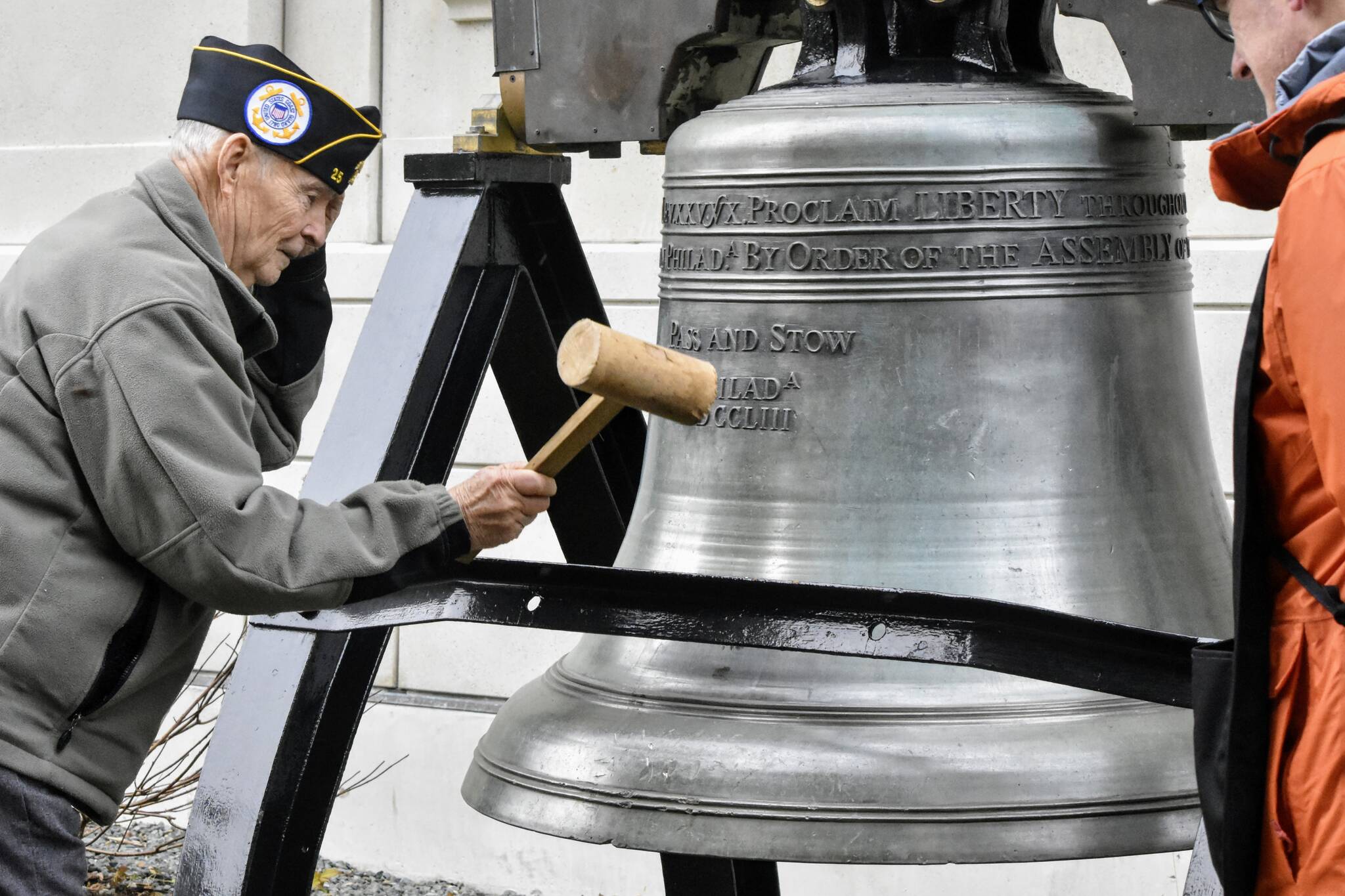 U.S. Coast Guard veteran Jim Wilcox Sr. strikes a replica of the Liberty Bell in front of the Alaska State Capitol on Nov. 11, 2021, during an Armistice Day celebration hosted by Veteran’s for Peace. The local VFP chapter holds bell ringings annually on Nov. 11, which is also Veterans Day, to remember all the lives lost to war and to call for world peace. (Peter Segall / Juneau Empire)
