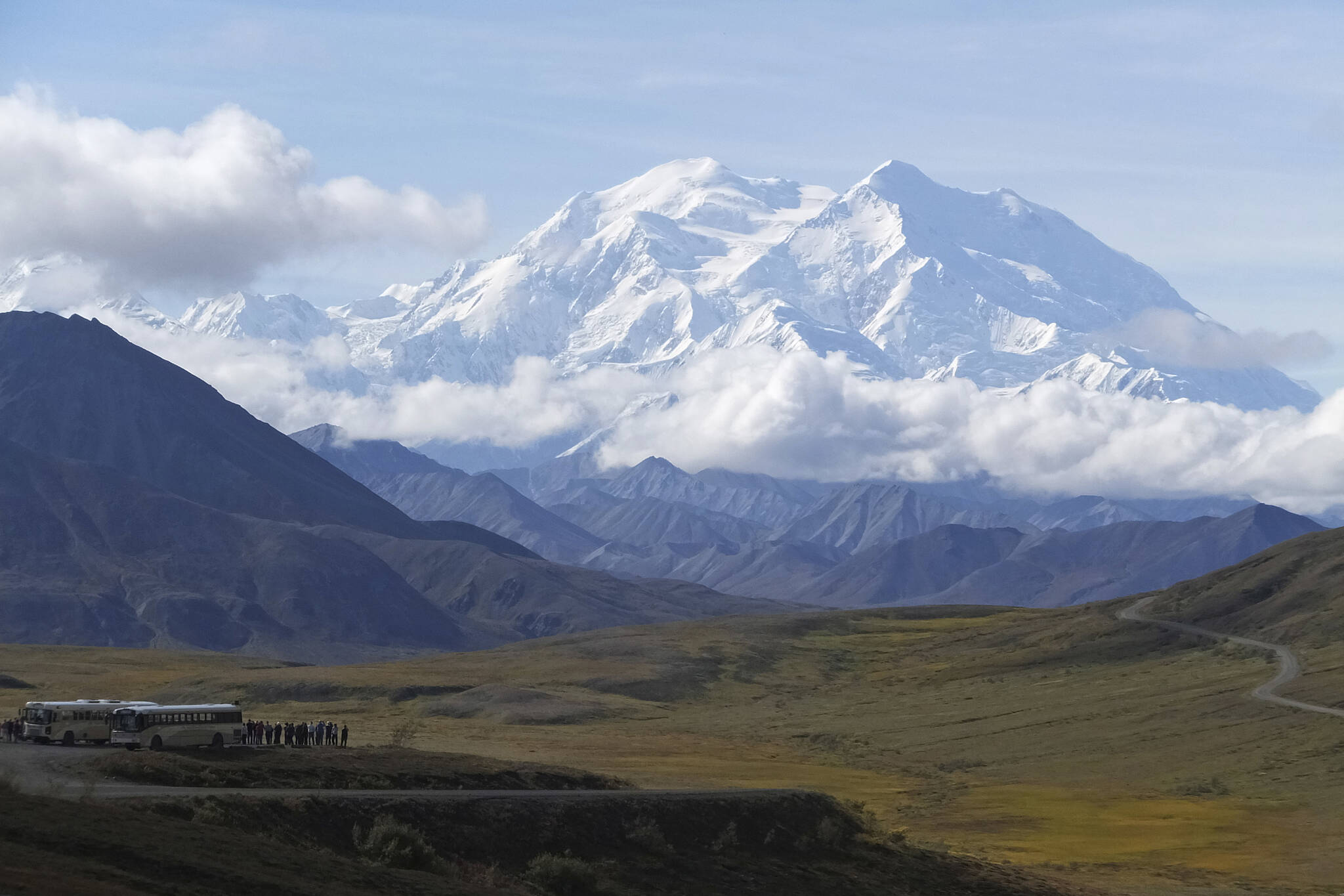 Sightseeing buses and tourists are seen at a pullout popular for taking in views of North America’s tallest peak, Denali, in Denali National Park and Preserve, Alaska, on Aug. 26, 2016. A Utah doctor is accused of lying to get a high-elevation helicopter to rescue him off the tallest mountain in North America and then destroying evidence. Dr. Jason Lance, who is a radiologist in Ogden, Utah, faces three misdemeanors, interfering with and violating the order of a government employee and for filing a false report from his May 2021, attempt to summit Denali, located about 180 miles north of Anchorage. (AP Photo / Becky Bohrer)