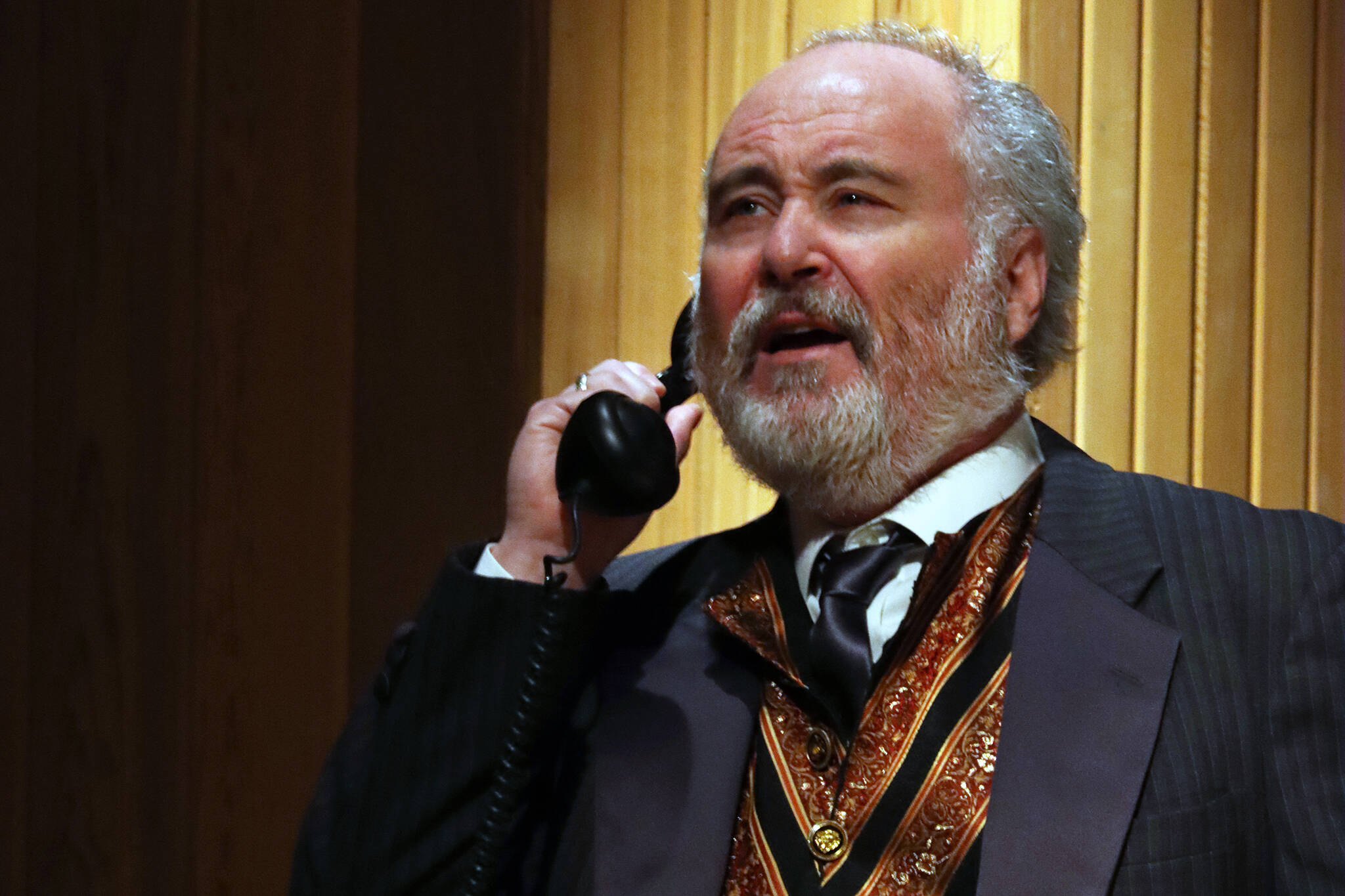 Arthur Birling (Dan Wayne) answers a phone call delivering unwelcome news during a dress rehearsal for Theatre in the Rough’s upcoming “An Inspector Calls.” (Ben Hohenstatt / Juneau Empire)