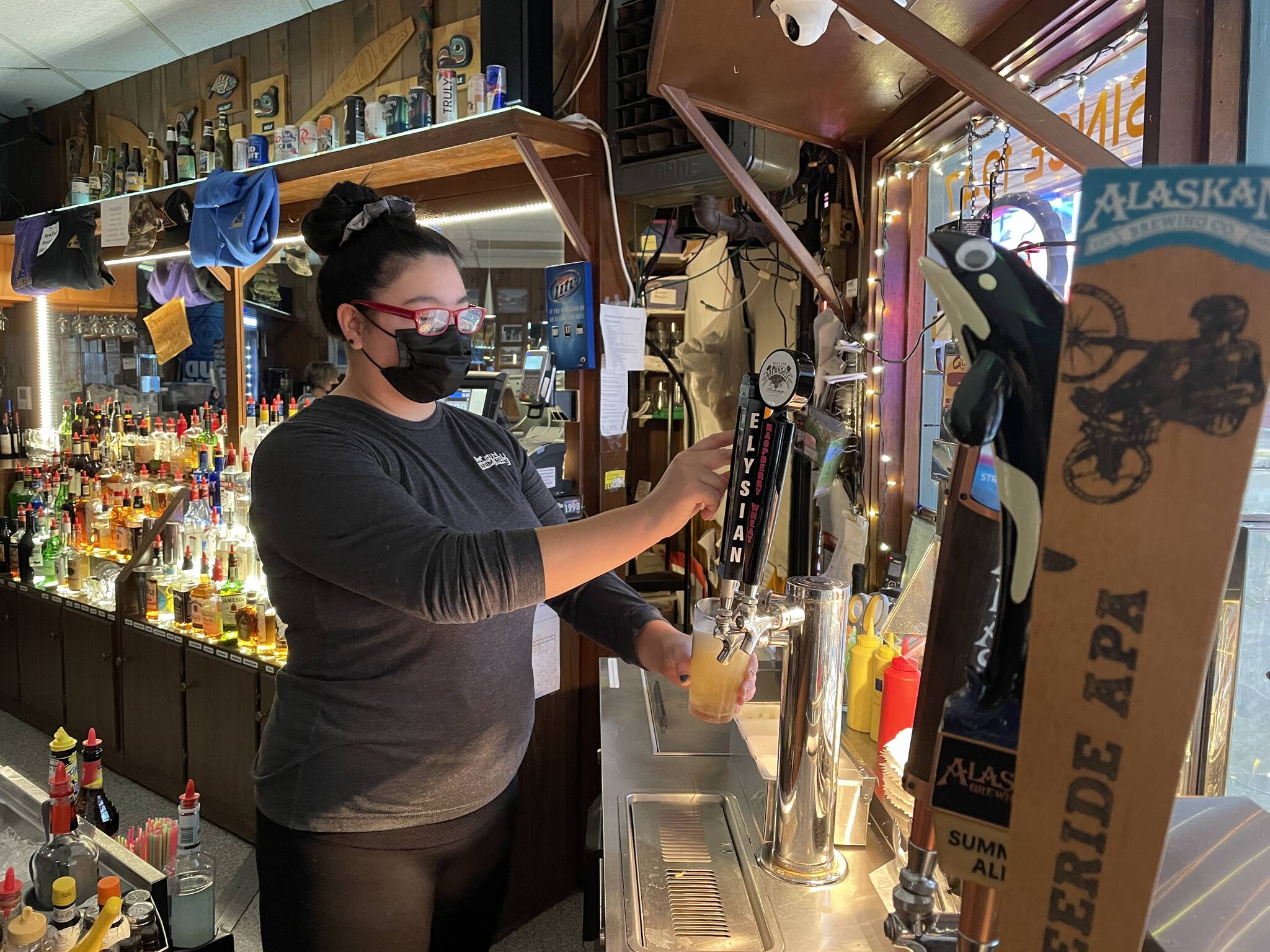Triangle Club bartender Sam Sims pulls a pint on Nov. 17, 2021 as Juneau recently announced that bars would be able to operate for their full hours under modified mitigation measures. (Michael S. Lockett / Juneau Empire)