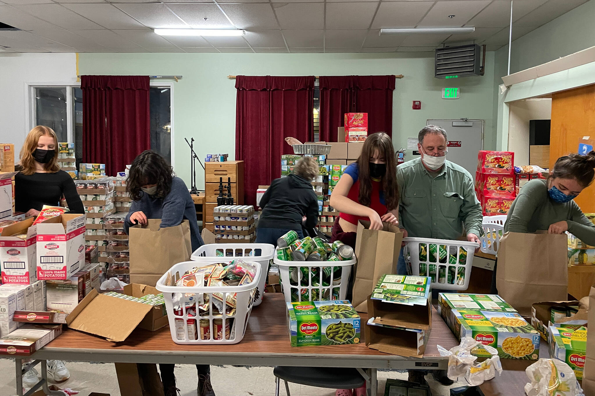 Volunteers from the Thunder Mountain High School Interact Club prepare Thanksgiving food baskets for the Juneau Society of St. Vincent de Paul on Nov. 18, 2021. (Michael S. Lockett / Juneau Empire)