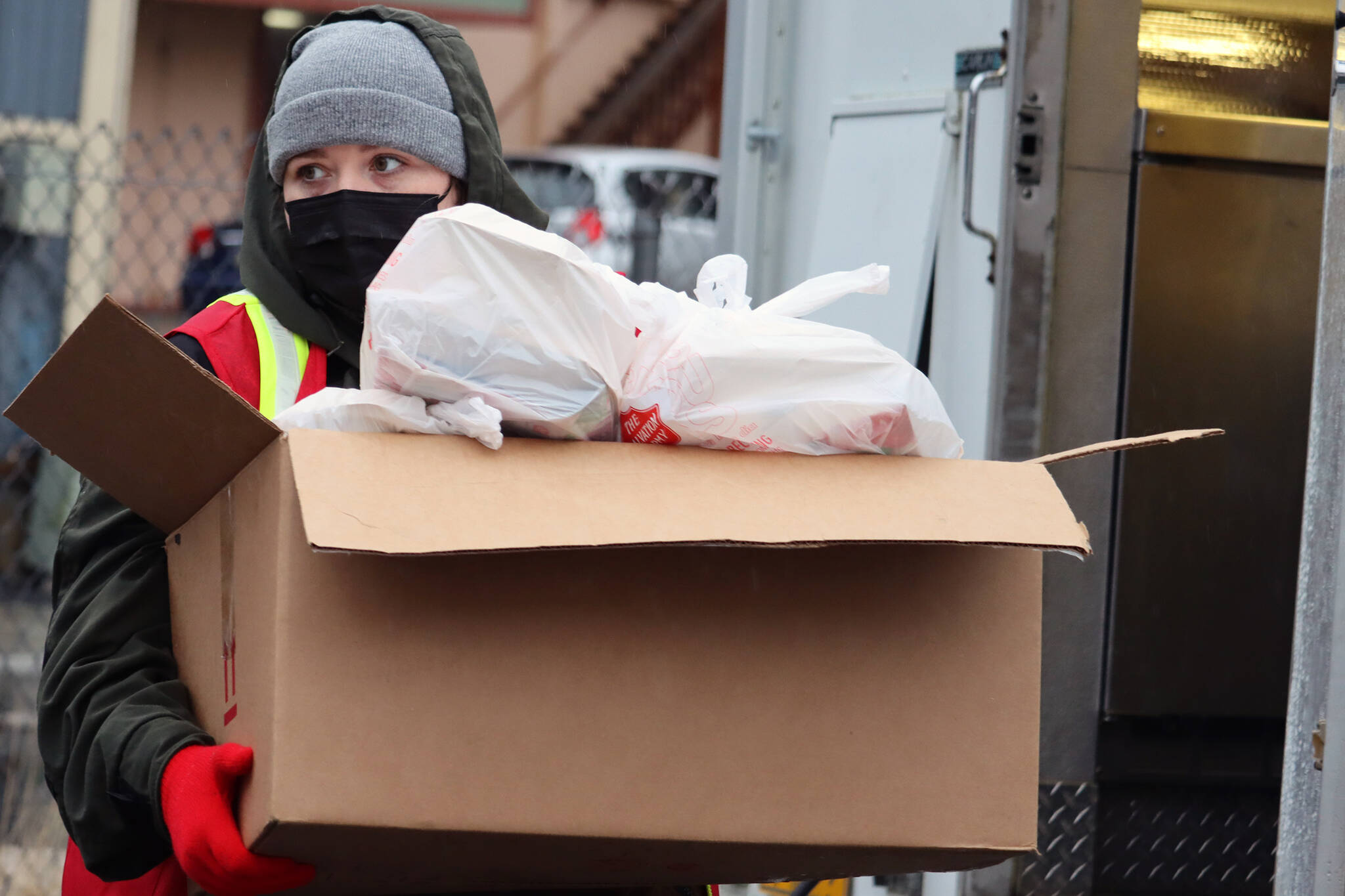 Meagan Bryd, an AmeriCorps volunteer, carries a box load of meals toward a vehicle for delivery on Thanksgiving. (Ben Hohenstatt Juneau Empire)