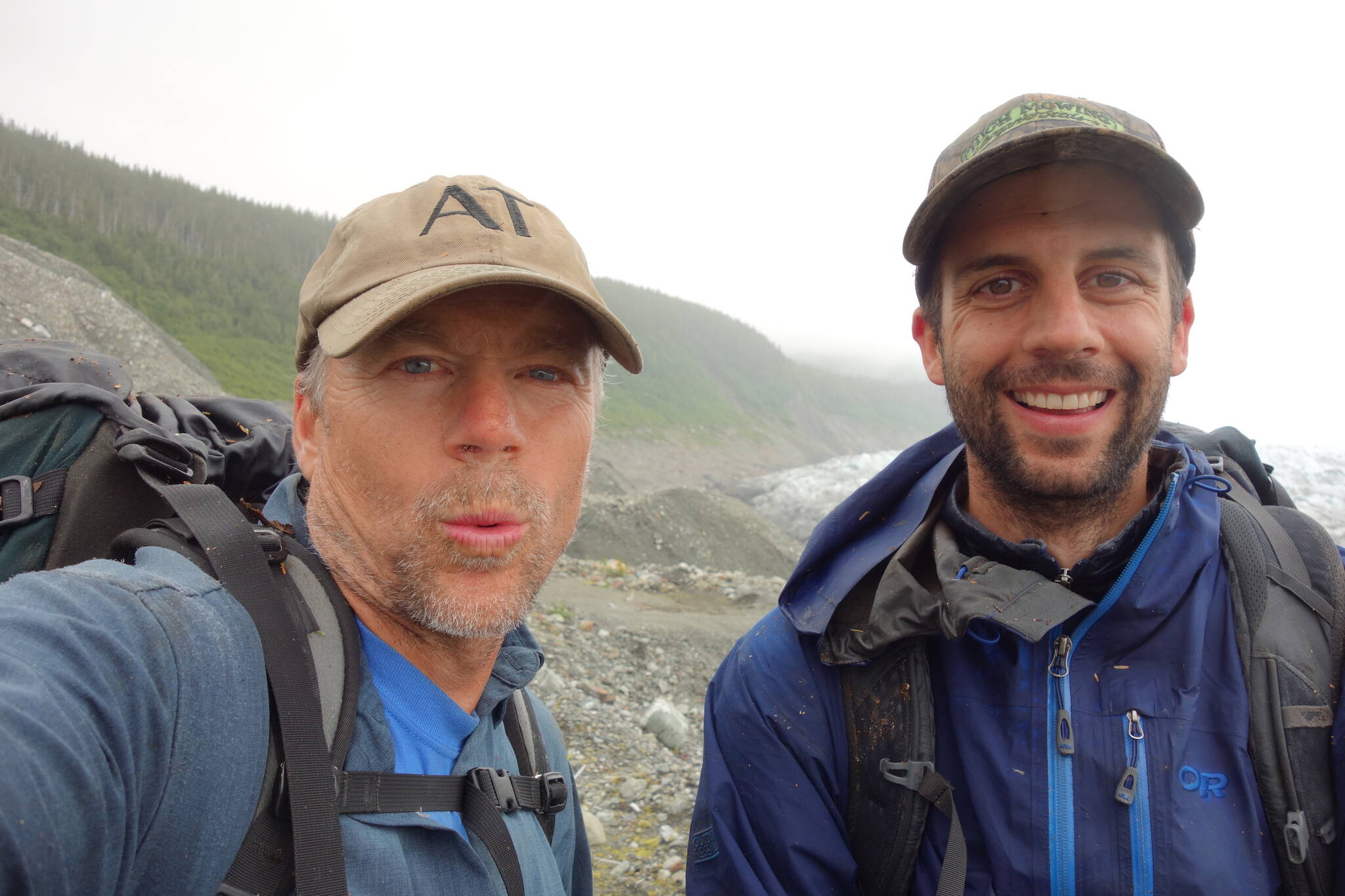 Science writer Ned Rozell, left, and UAF ecologist Ben Gaglioti pause after a slippery, seven-hour rainforest hike near La Perouse Glacier on July 3, 2021. (Courtesy Photo / Ned Rozell)