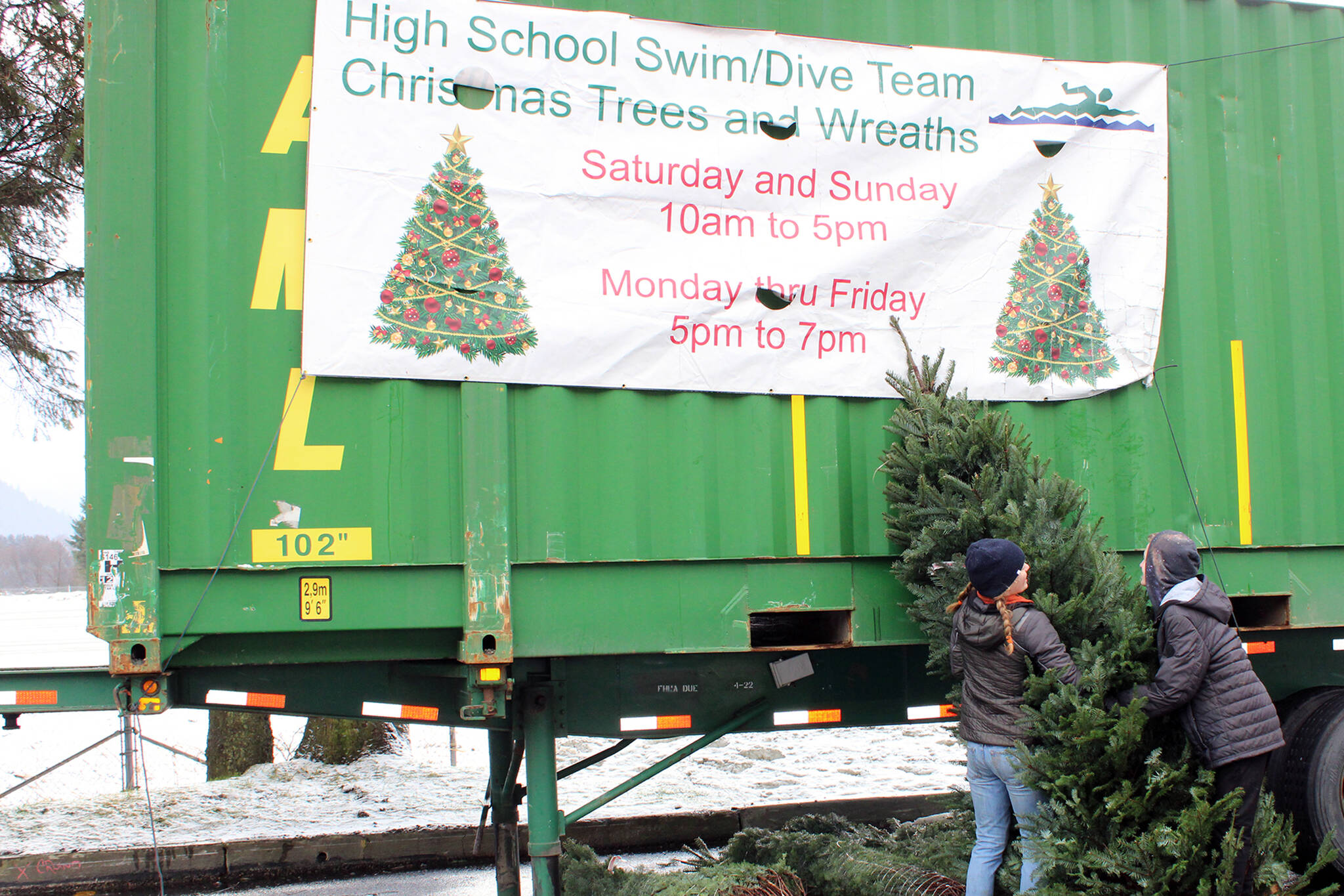 Dana Zigmund / Juneau Empire 
Owen Rumsey and Pacific Ricke, both Juneau-Douglas High School: Yadaa.at Kalé freshmen, move a Christmas tree during the swimming and diving team’s annual tree and wreath sale. The JDHS and Thunder Mountain High School swim and dive teams are selling Christmas trees and wreaths. Trees start at $50 and wreaths are $40, delivery is offered for $25. The sale will be open every evening but with different hours on weekends. Weekdays, the sale will be open from 5-7 p.m. and 10 a.m.-5 p.m. on weekends. Online ordering is available at jdswimdive.org.