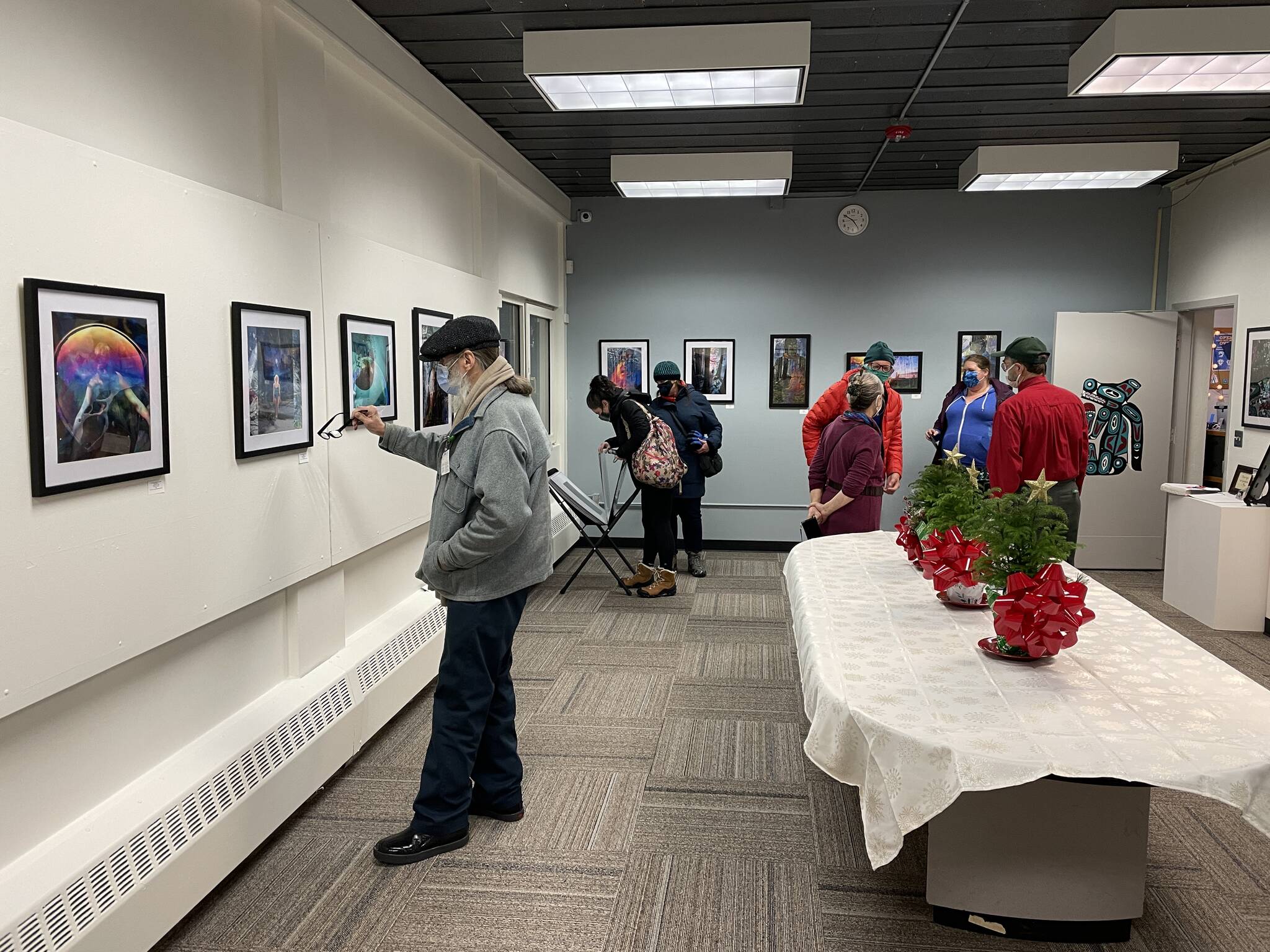Gallery Walkers peruse the art of Fawn Waterfield at the Juneau Arts and Culture Center on Dec. 3, 2021. (Michael S. Lockett / Juneau Empire)