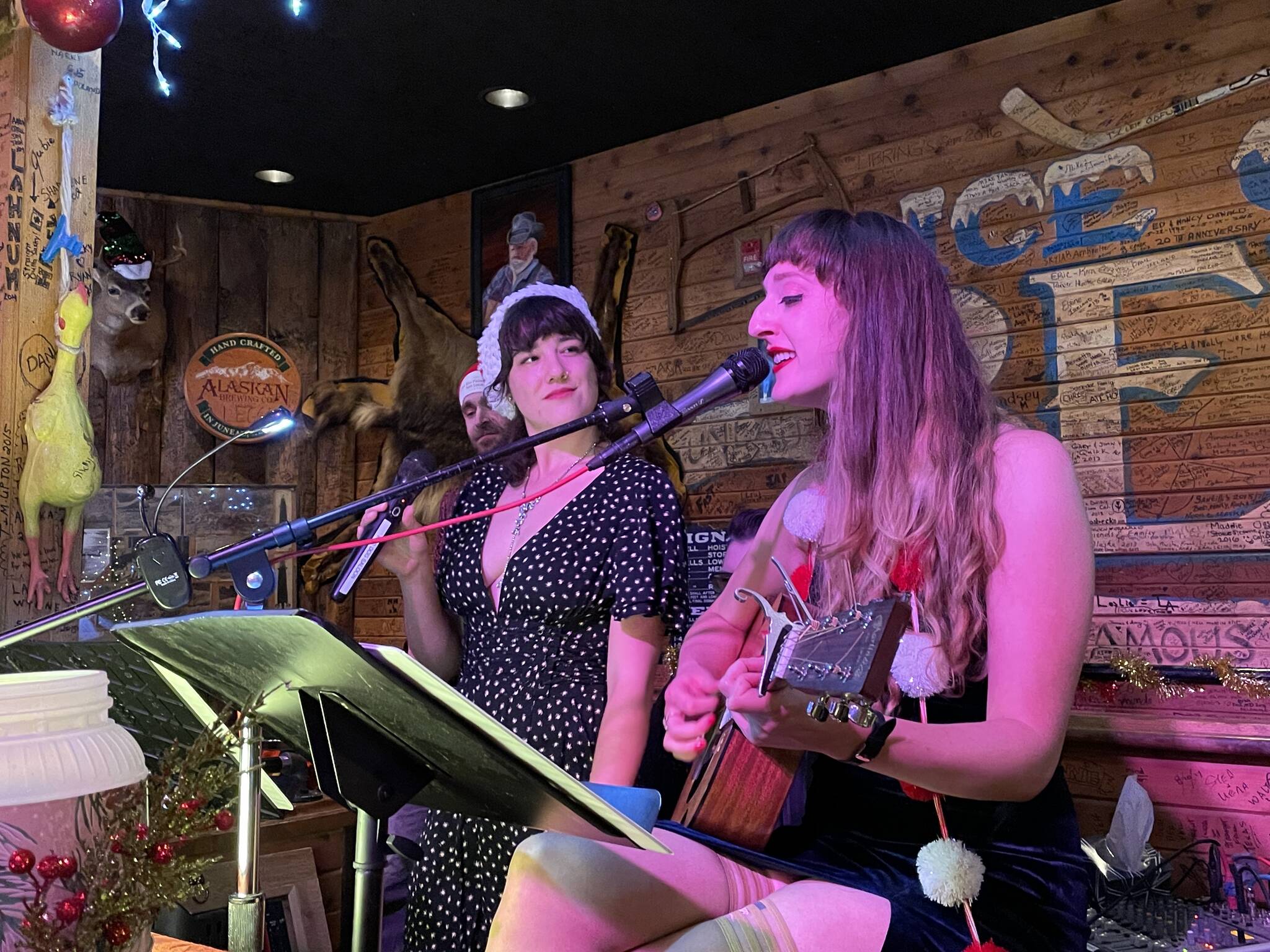 Taylor Vidic and Kelsey Riker sing at the Red Dog Saloon during Gallery Walk on Dec. 3, 2021. (Michael S. Lockett / Juneau Empire)