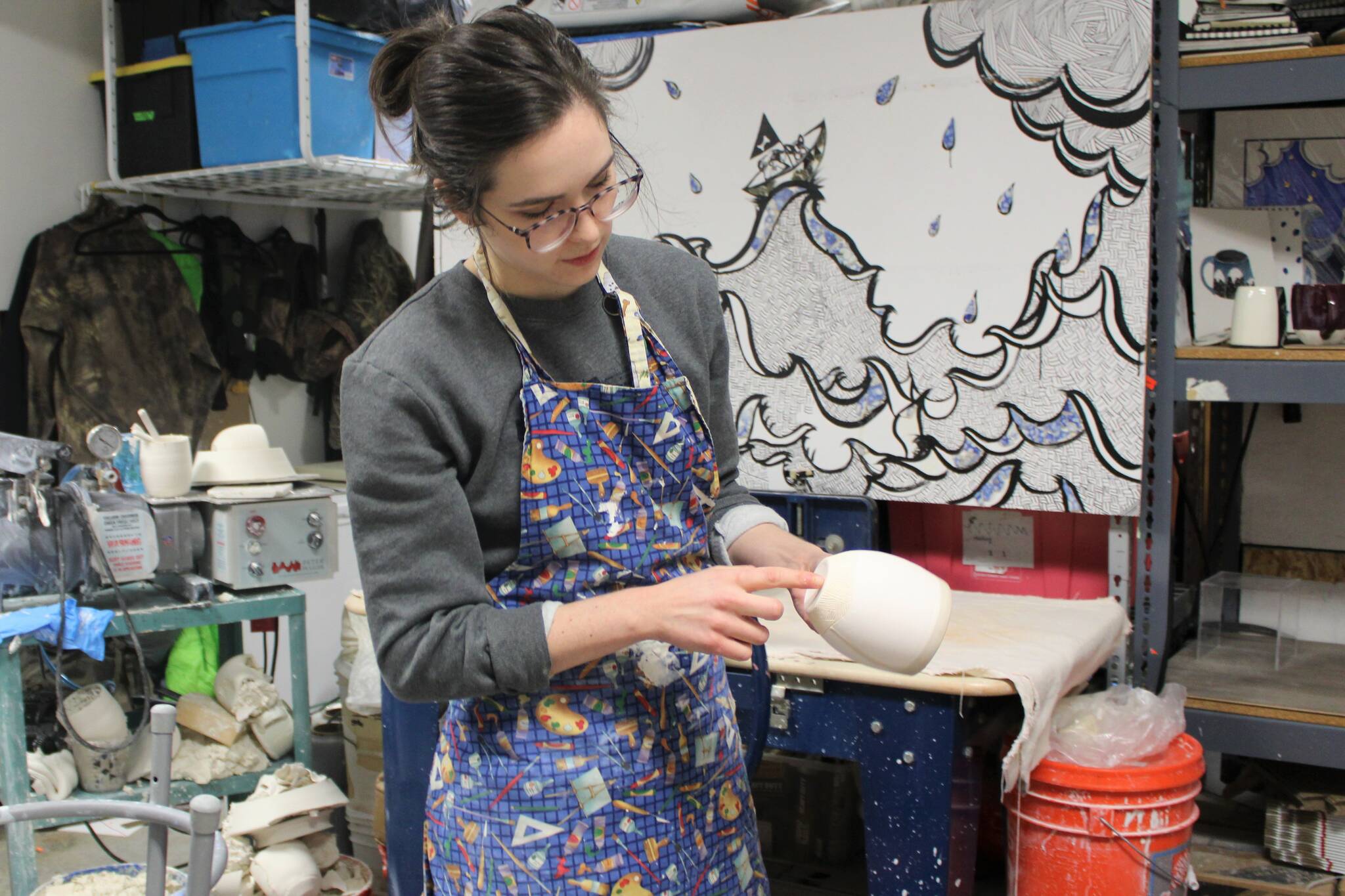 Mercedes Muñoz at work in her Lena Loop studio in Dec. 12. Her original sketch hangs in the background of her ceramics studio. (Dana Zigmund/Juneau Empire)
