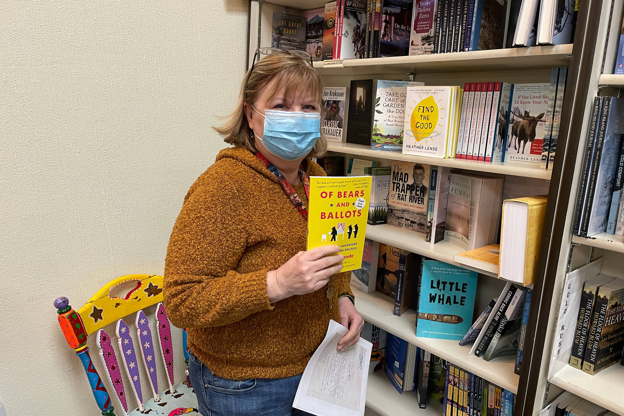 Brenda Weaver, owner of Hearthside Books and Toys, holds up the most recent book by Heather Lende, recently chosen as the Alaska State Writer Lauereate. (Michael S. Lockett / Juneau Empire)