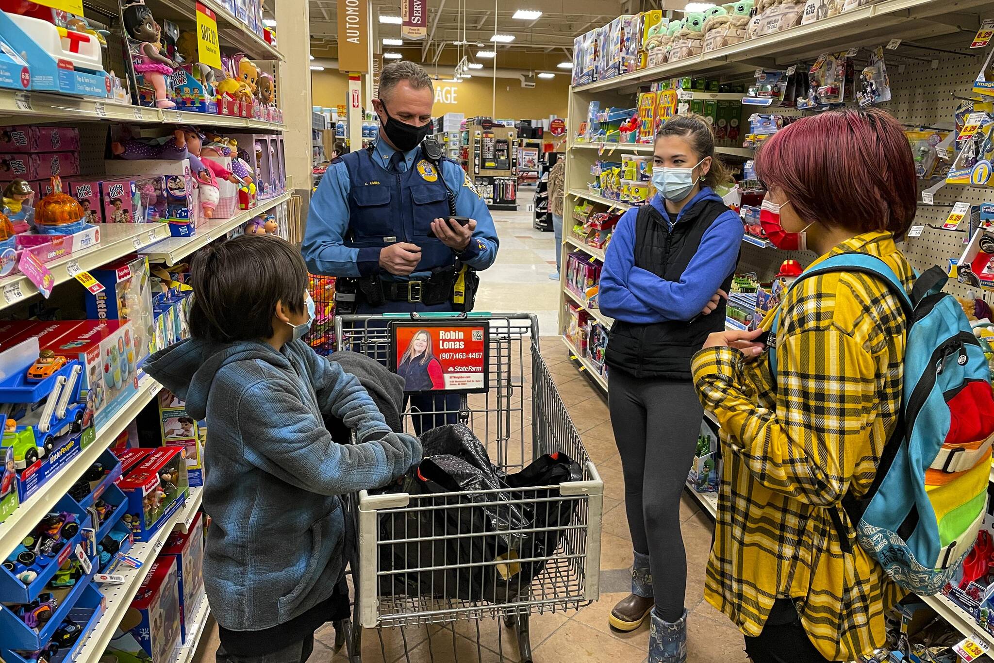 Alaska State Trooper Chris Umbs and Victoria Larson talk to Ethan and Wilbur during the annual Shop with a Cop Event at Fred Meyer on Dec. 18, 2021. (Michael S. Lockett / Juneau Empire)