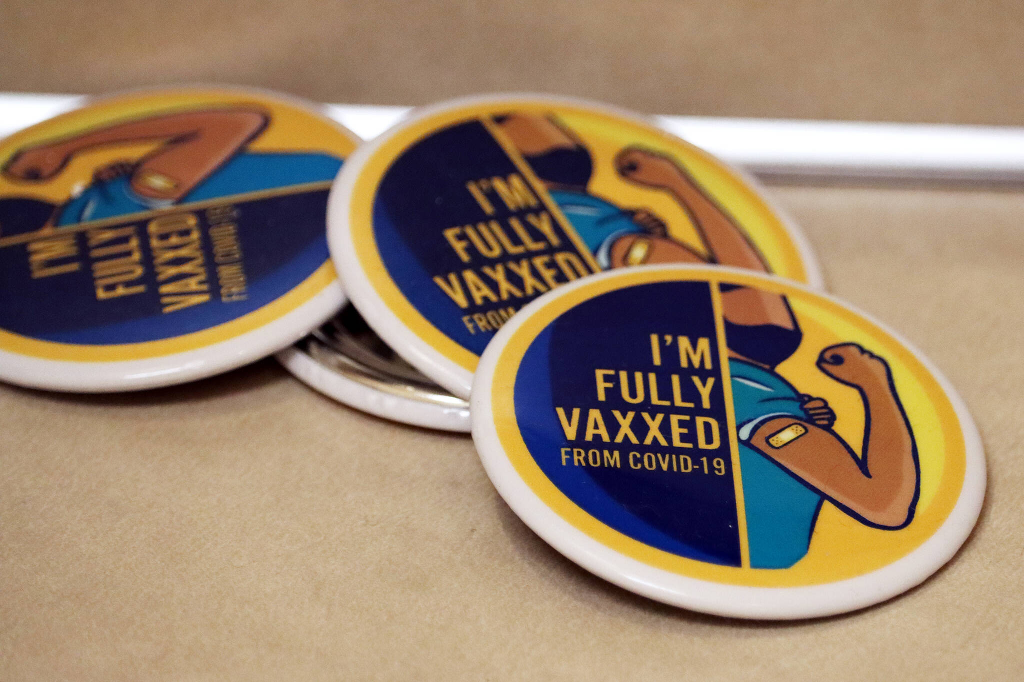 ”I’m full vaxxed from COVID,” read buttons at the Juneau Public Health Center in late November. Juneau’s relatively high vaccination rate plays a role in the local response to the ongoing pandemic. At Monday night’s Committee of the Whole meeting, City Assembly members agreed to move a step closer to “modest relaxations” to the city’s COVID-19 mitigation strategies and heard from state experts who praised Juneau’s performance in keeping the worst at bay so far. (Ben Hohenstatt / Juneau Empire)