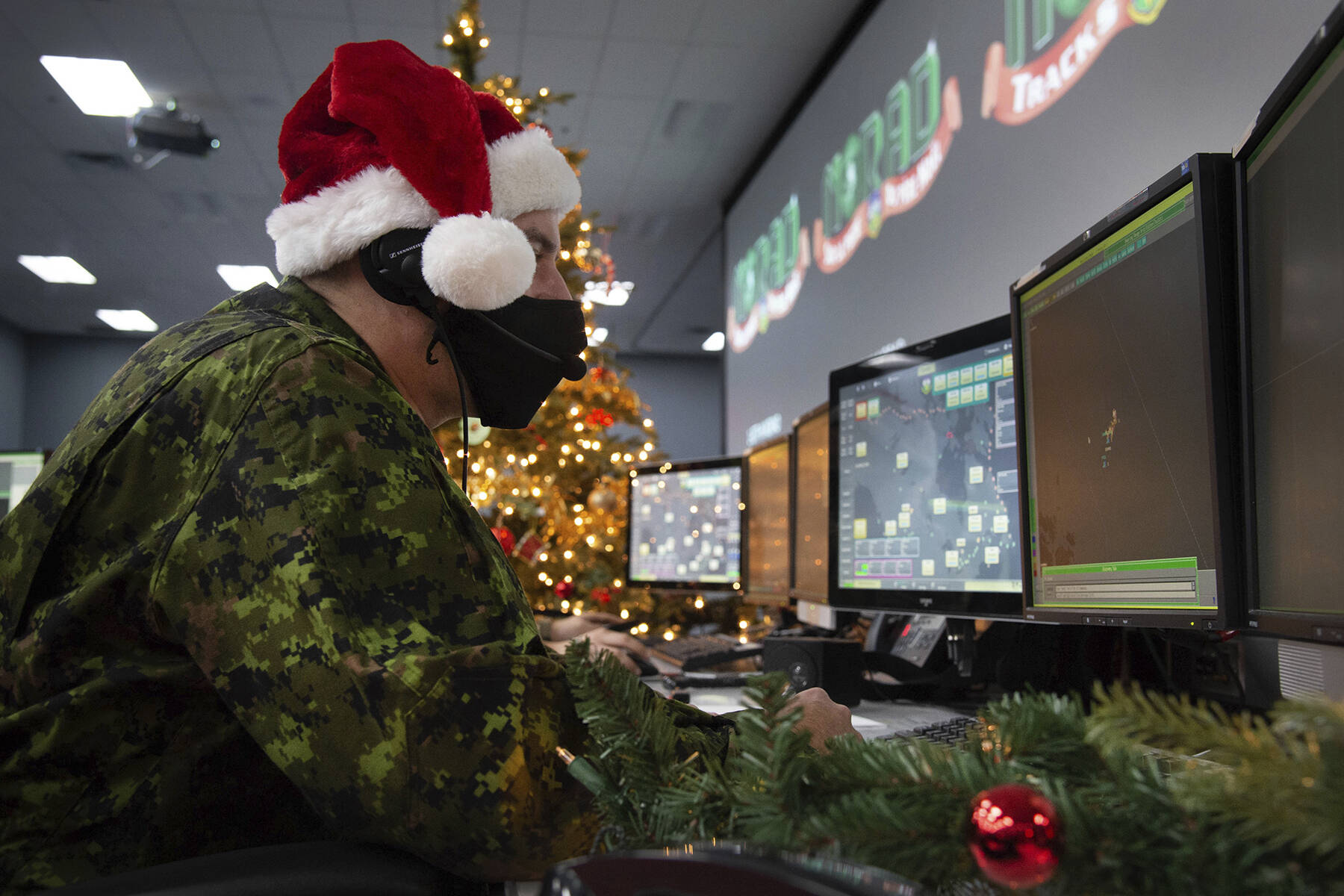 In this photo provided by the North American Aerospace Defense Command, a 22 Wing member is seen showing how they track Santa on his sleigh on Christmas evening during a media preview at the Canadian Forces Base in North Bay on Dec. 9, 2021. In a Christmas Eve tradition going on its 66th year, a wildly popular program run by the U.S. and Canadian militaries is providing real-time updates on Santa’s progress around the globe — and fielding calls from children who want to know St. Nick’s exact whereabouts. (Sable Brown / NORAD)