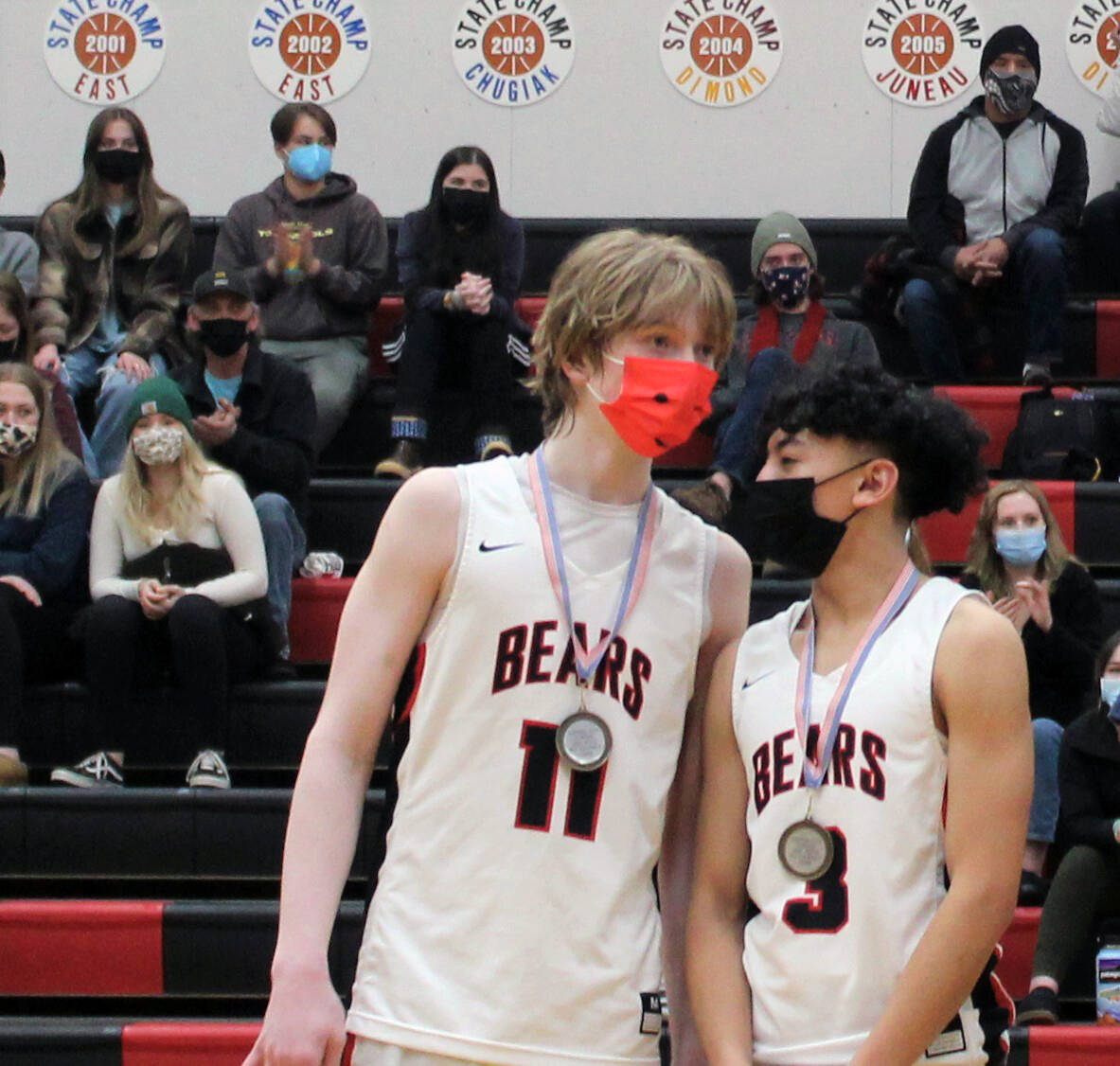 Sophomores Sean Oliver, left, and Alwen Carrillo, right, from the Juneau-Douglas High School: Yadaa.at Kalé basketball team accept all-tournament honors. (Dana Zigmund/Juneau Empire)