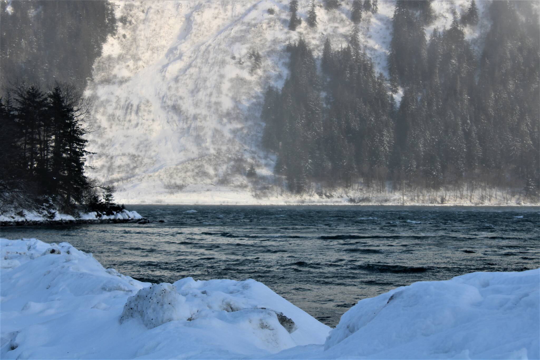 Waves pummel Sandy Beach on Douglas on Jan. 3. Avalanche debris from a weekend slide on Thane Road is visible across the Gastineau Channel. The avalanche delayed crews in responding to a power outage further down Thane Road. (Dana Zigmund / Juneau Empire)