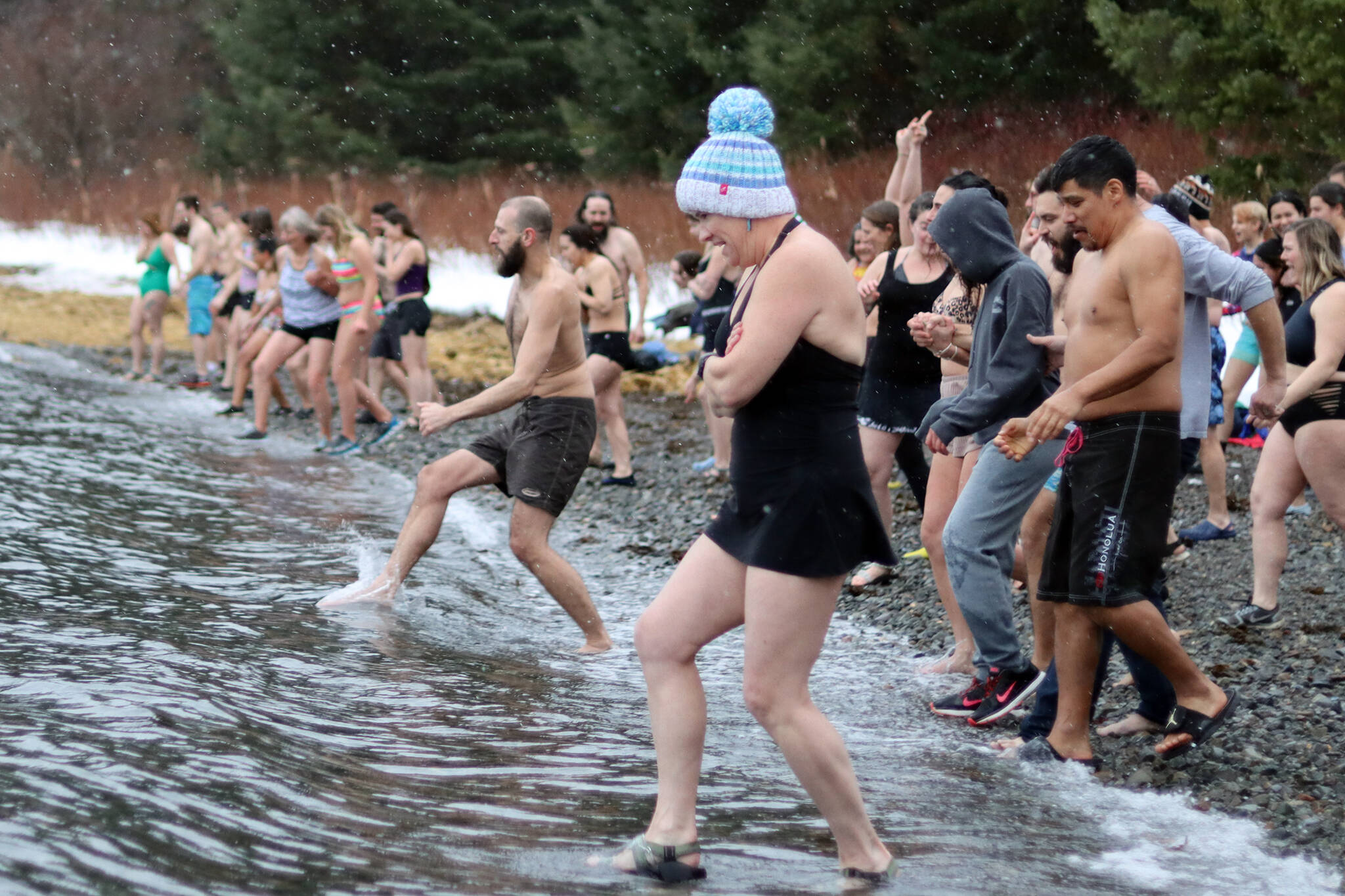 Participants move quickly but gingerly into the water at the 2022 Polar Dip held Saturday. (Ben Hohenstatt / Juneau Empire)