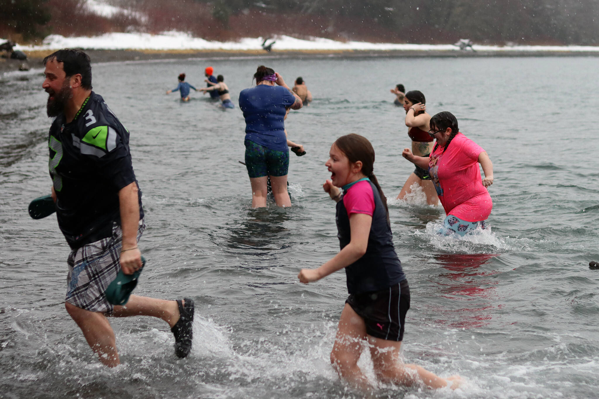 Participants rush back to shore following the 2022 Polar Dip on Saturday. (Ben Hohenstatt / Juneau Empire)