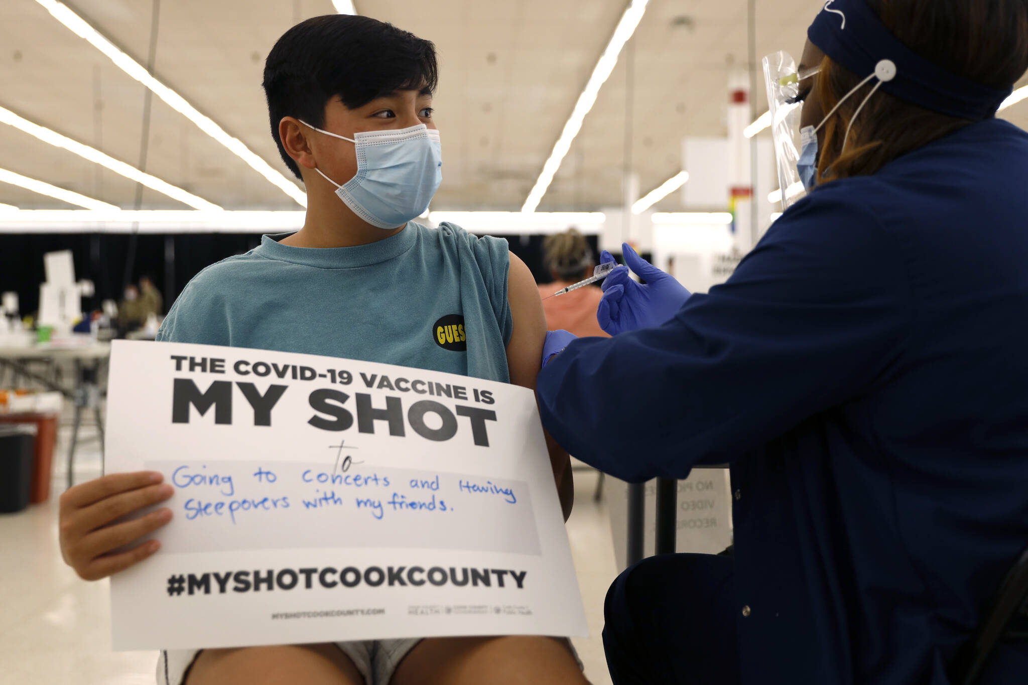 Lucas Kittikamron-Mora, 13, holds a sign in support of COVID-19 vaccinations as he receives his first Pfizer vaccination at the Cook County Public Health Department, May 13, 2021 in Des Plaines, Ill. The U.S. is expanding COVID-19 boosters as it confronts the omicron surge, with the Food and Drug Administration allowing extra Pfizer shots for children as young as 12. Boosters already are recommended for everyone 16 and older, and federal regulators on Monday, Jan. 3, 2022 decided they’re also warranted for 12- to 15-year-olds once enough time has passed since their last dose. (AP Photo / Shafkat Anowar)
