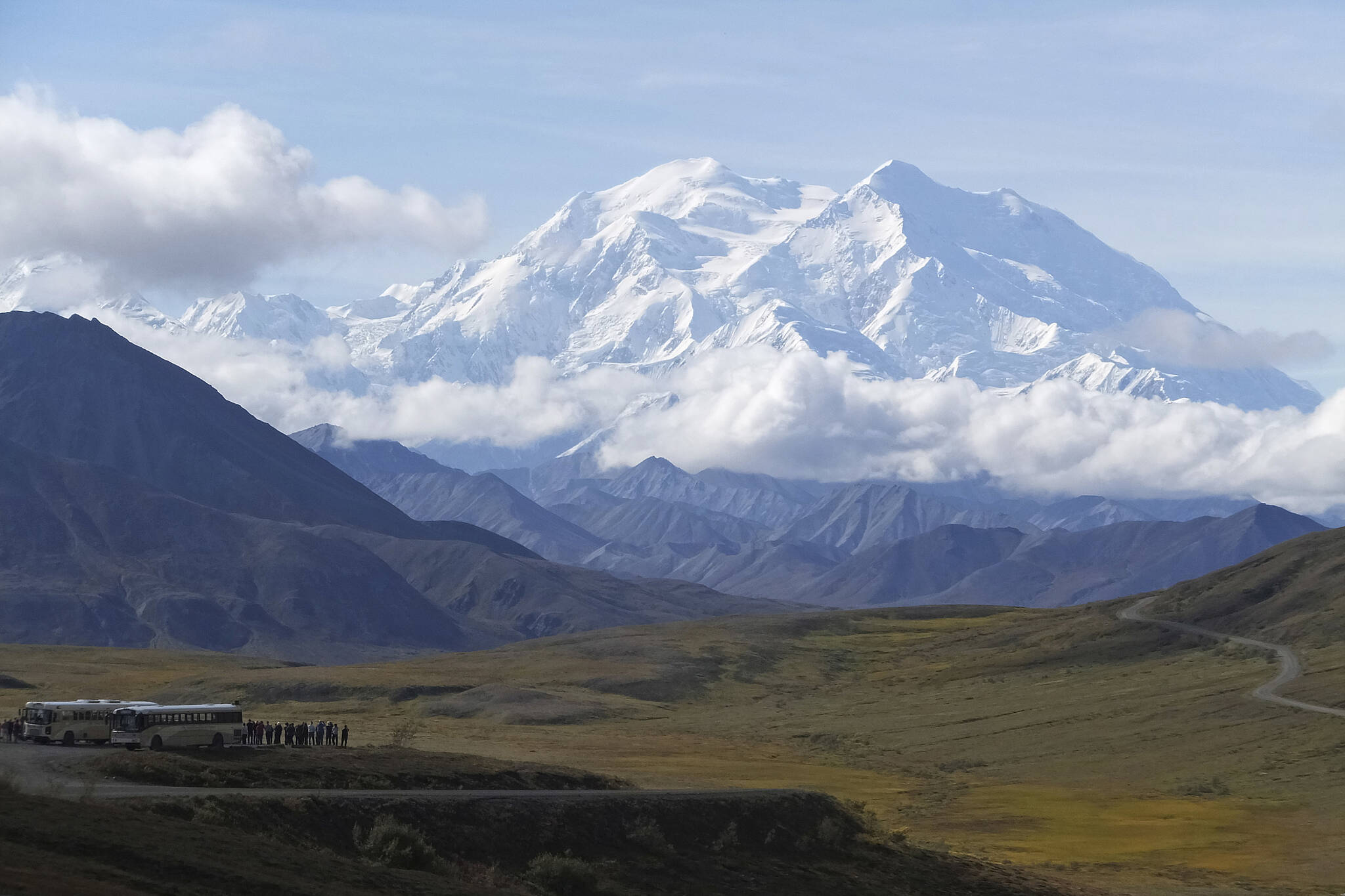 Sightseeing buses and tourists are seen at a pullout popular for taking in views of North America’s tallest peak, Denali, in Denali National Park and Preserve, Alaska, on Aug. 26, 2016. The U.S. Interior Department plans to use $25 million in federal infrastructure funds on a bridge project over a slumping section of the only road into Denali National Park and Preserve. Park officials have attributed the accelerated slumping to climate change, and closed about half the 92-mile park road until they can address the repairs. (AP Photo / Becky Bohrer)