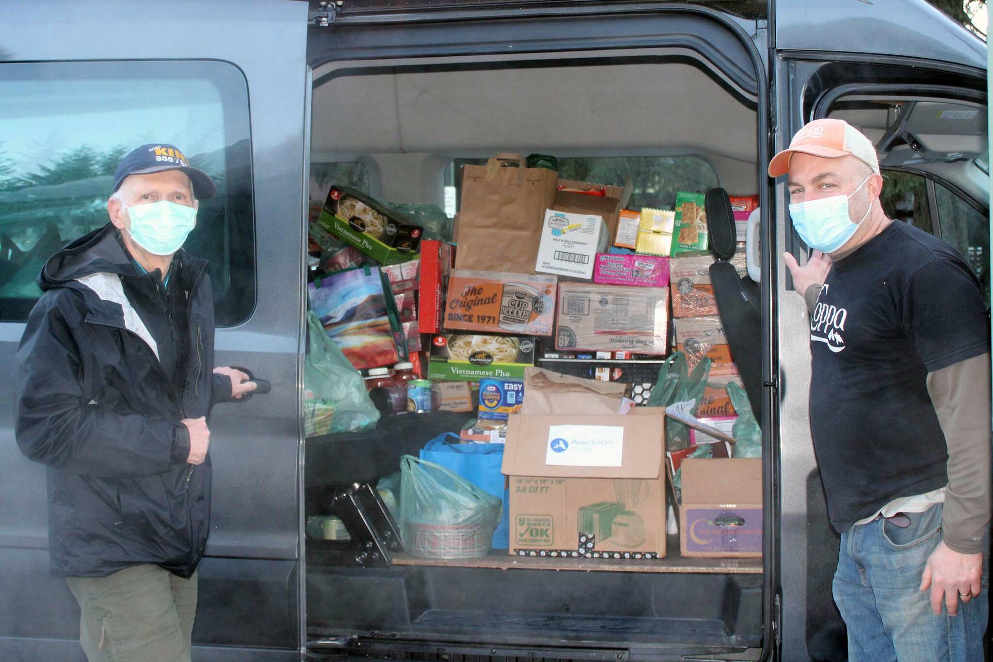 Mike Ricker and Marc Wheeler load donated food items into a van bound for the Glory Hall on Jan. 17. The items were donated as part of a drive to collect food and household goods in honor of Martin Luther King Jr. Day. (Dana Zigmund / Juneau Empire)