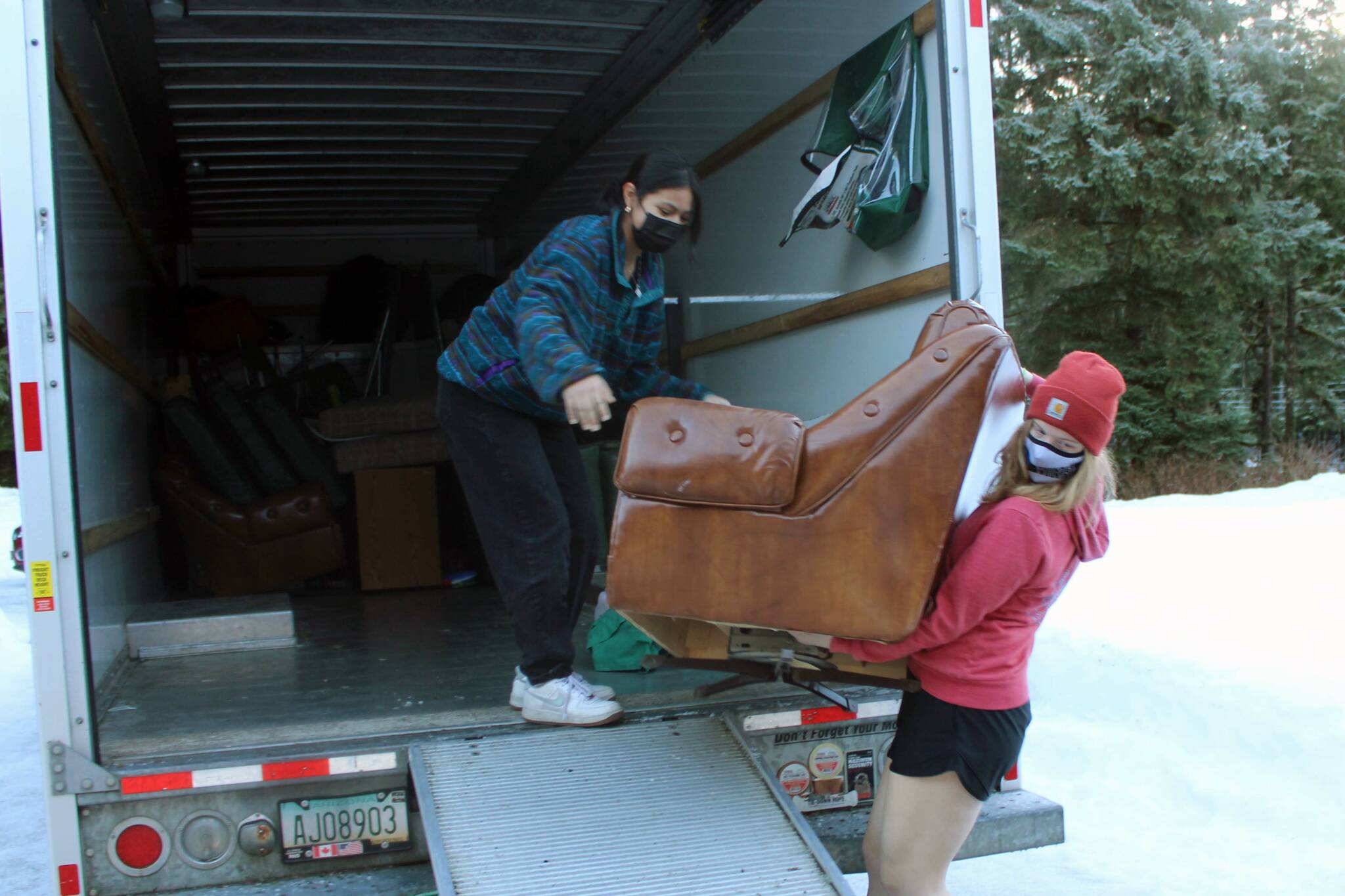 Mercedes Cordero, left, a junior at Thunder Mountain High School, and Gwen Lockwood, a senior at TMHS moved a chair at Chapel by the Lake on Jan. 17. The pair, along with about 20 other high school students, spent part of their Martin Luther King Jr. holiday chipping in with other volunteers readying the church to receive students from Riverbend School. (Dana Zigmund/Juneau Empire)
