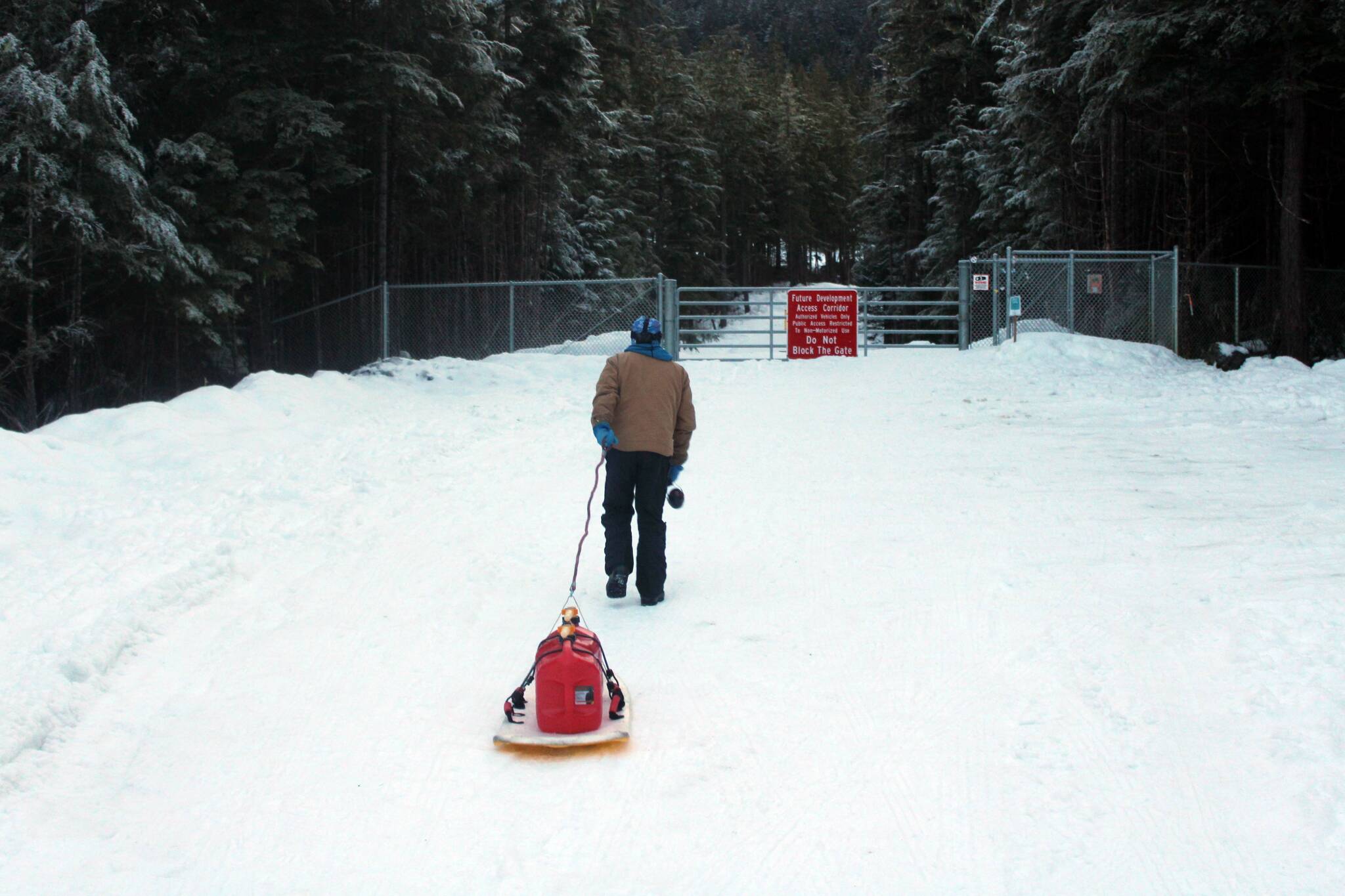 Wayne Carnes, a volunteer with the Juneau Nordic Ski Club, pulls gas tanks to the entrance of Pioneer Road on North Douglas on Jan. 18. (Dana Zigmund/Juneau Empire)