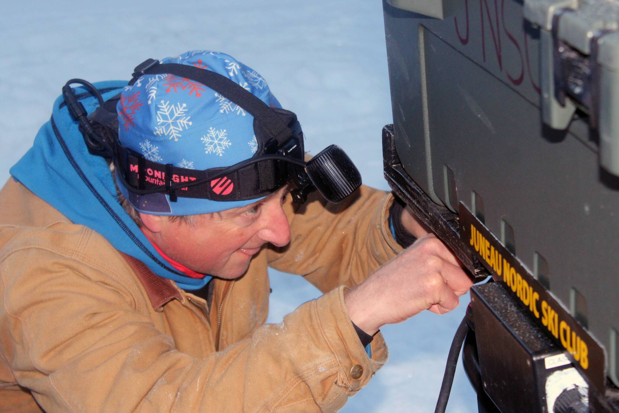 Wayne Carnes tinkers with the Juneau Nordic Ski Club’s snow machine before grooming the trail at Pioneer Road on Jan. 18. (Dana Zigmund/Juneau Empire)