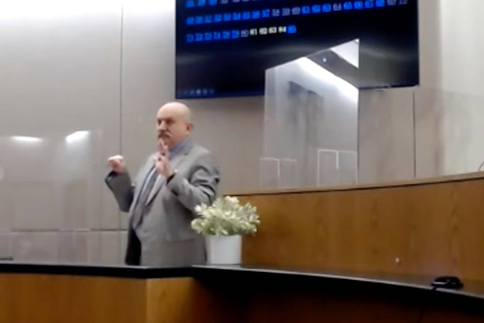 Ted Nordgaarden of the Alaska Bureau of Investigation imitates the gesture made by the defendant during the trial of a man charged with killing another man in Yakutat in 2018. (Screenshot)