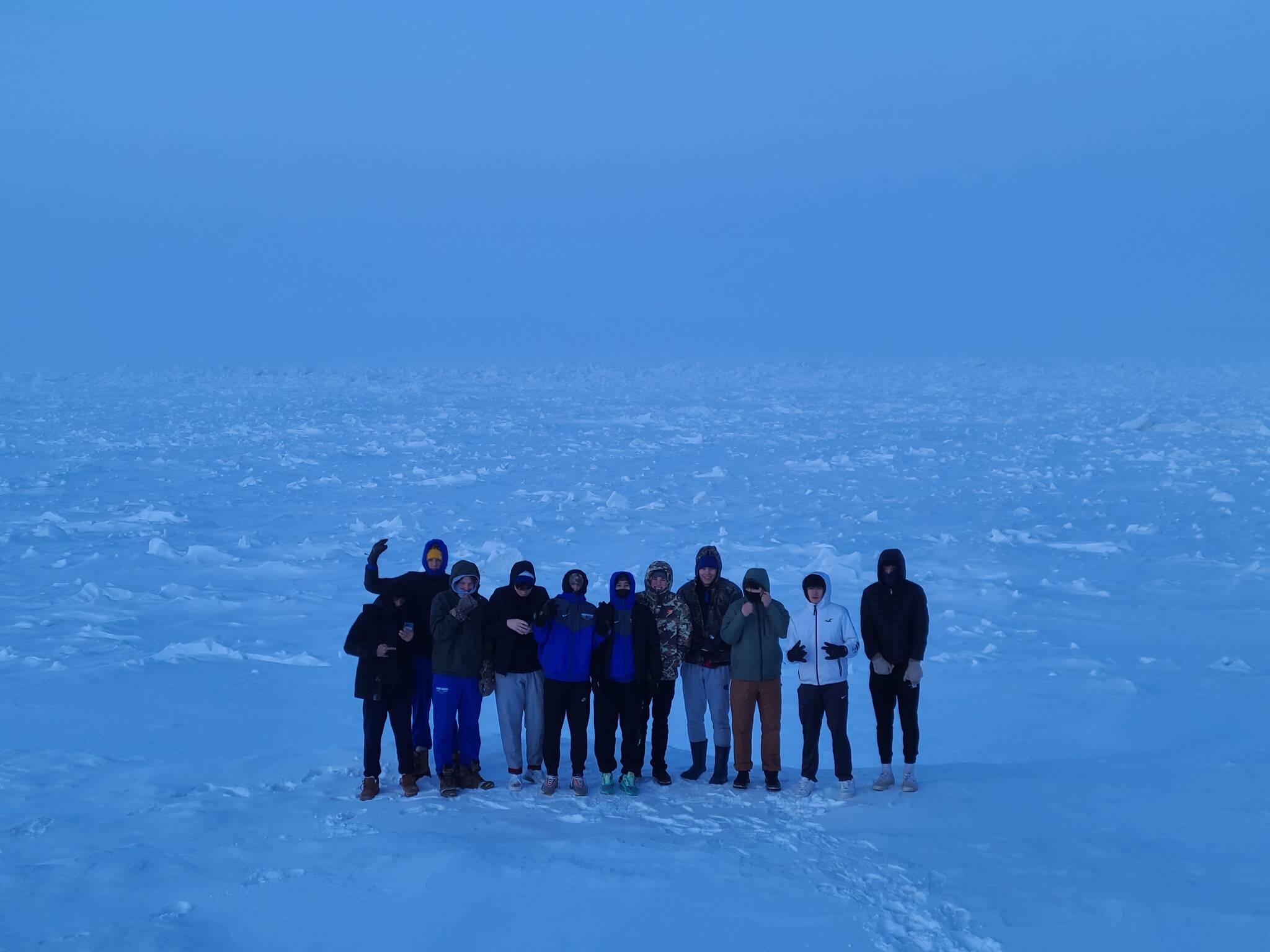 The Thunder Mountain High School boys basketball team stand on the Arctic Ocean. (Courtesy Photo)