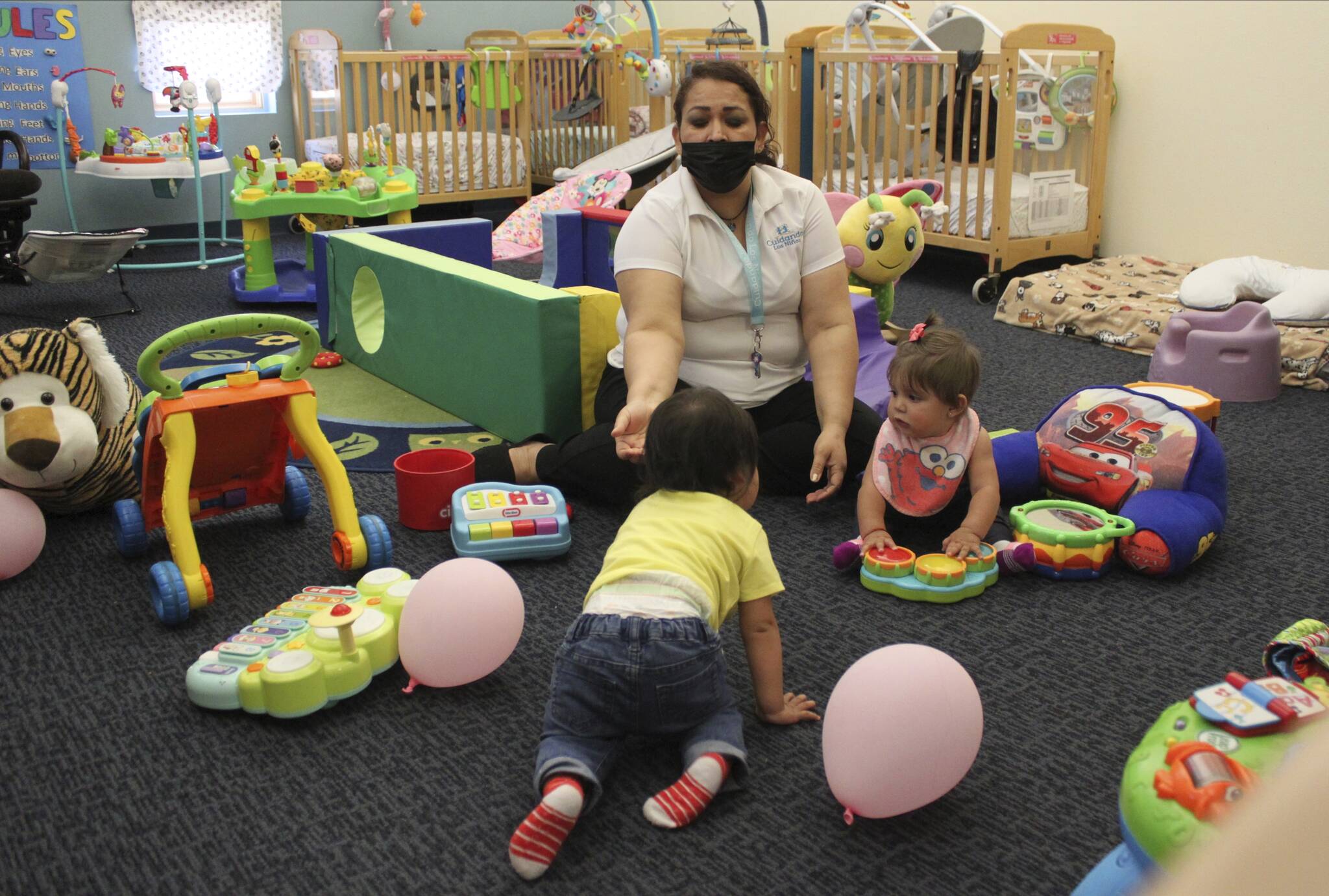This May 4, 2021 image shows teacher Graciela Olague-Barrios working with two infants at Cuidando Los Ninos in Albuquerque, N.M. According to a recent report by the U.S. Chamber Foundation, childcare is in short supply across the country. Local experts say Juneau lacks affordable, reliable childcare. (AP Photo / Susan Montoya Bryan)