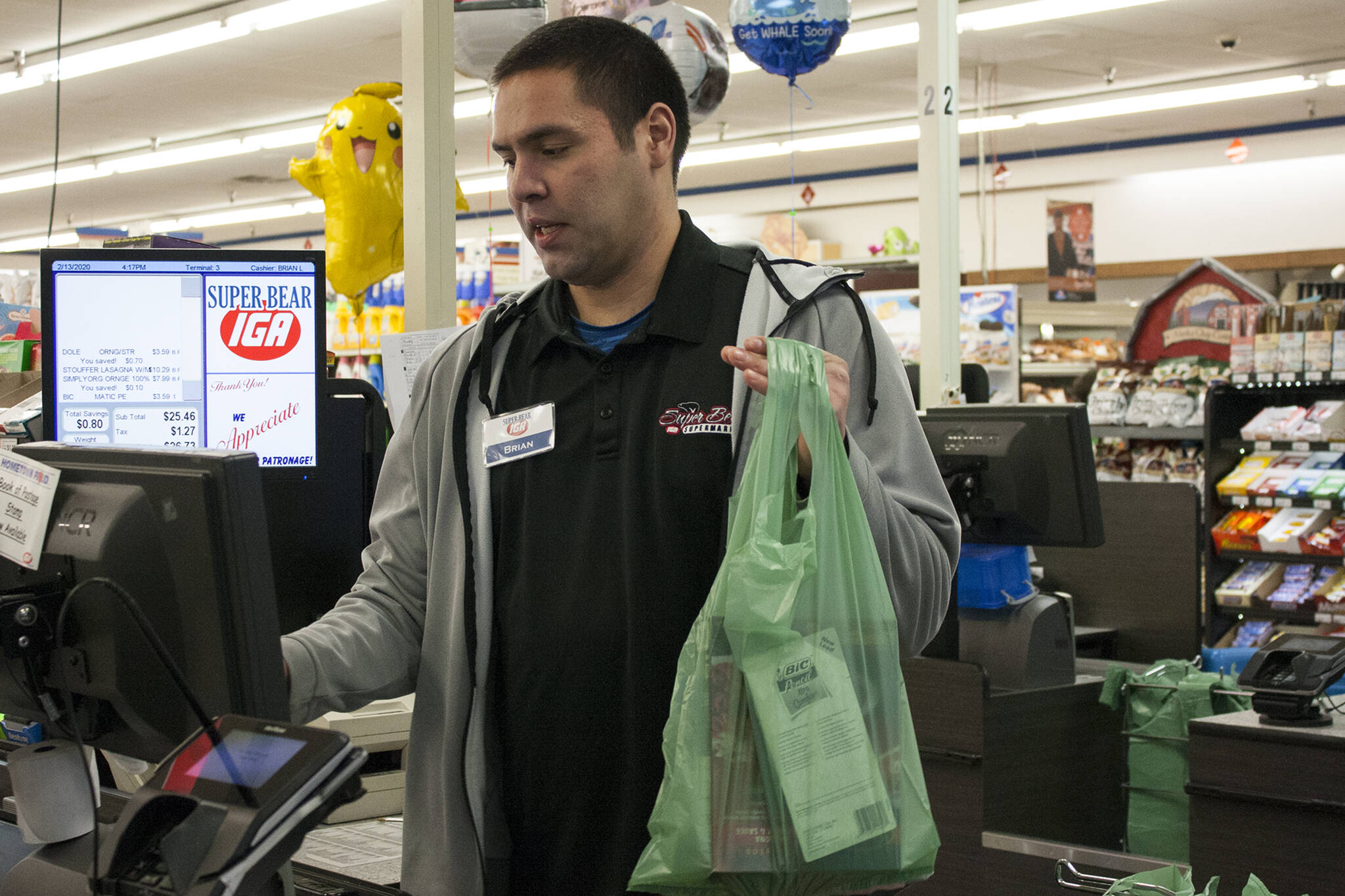 Brian Lauth, closing manager for Super Bear Supermarket IGA, bags groceries Thursday, Feb. 13, 2020. Next month, the Finance Committee for the City and Borough of Juneau will consider whether to exempt grocery purchases from the city’s sales tax. (Ben Hohenstatt/Juneau Empire File)
