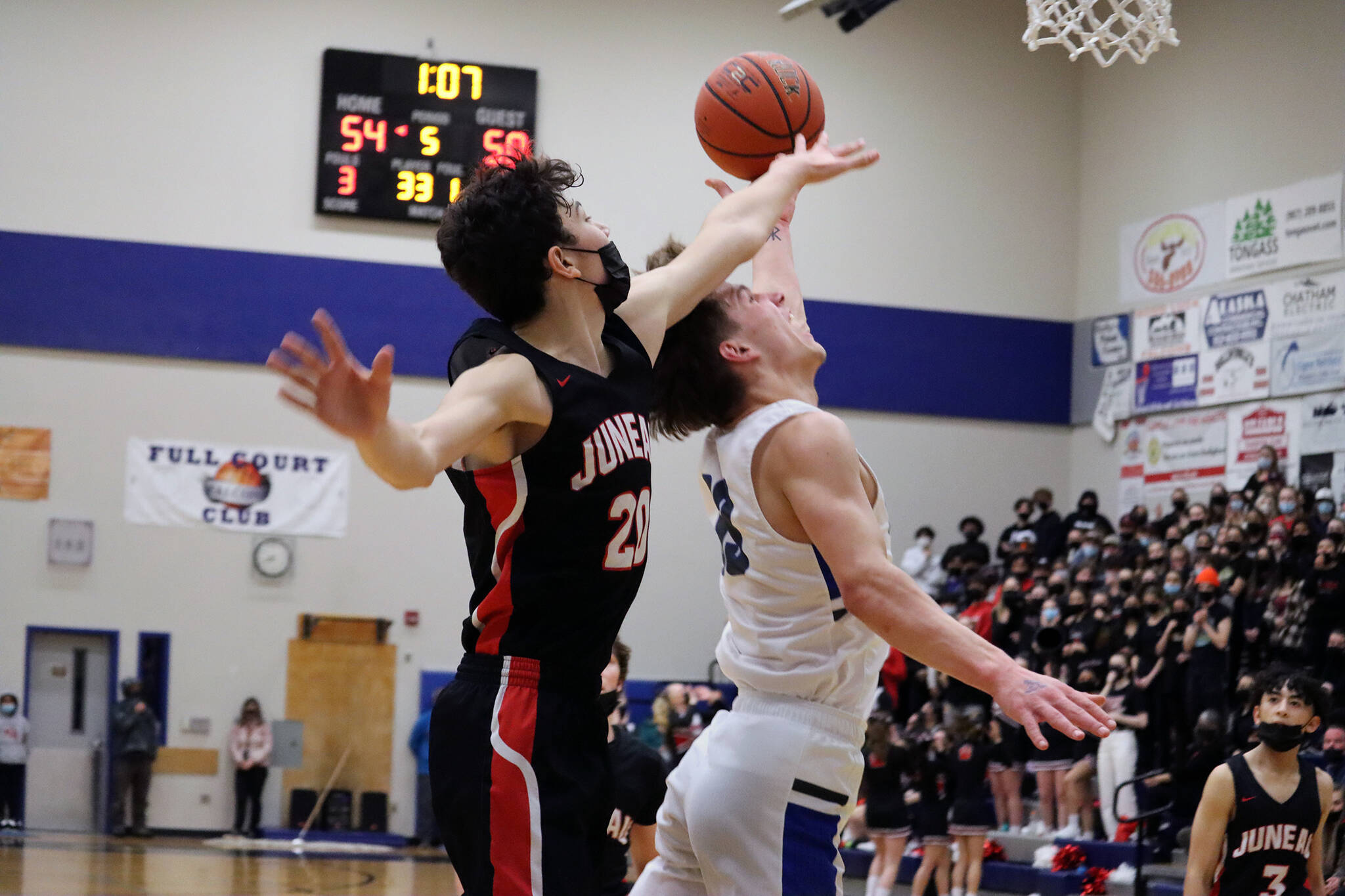 JDHS’ Orion Dybdahl contests a shot from TMHS’ Thomas Baxter late in Saturday night’s game. Thunder Mountain High School wound up winning 56-55 in overtime. (Ben Hohenstatt / Juneau Empire)