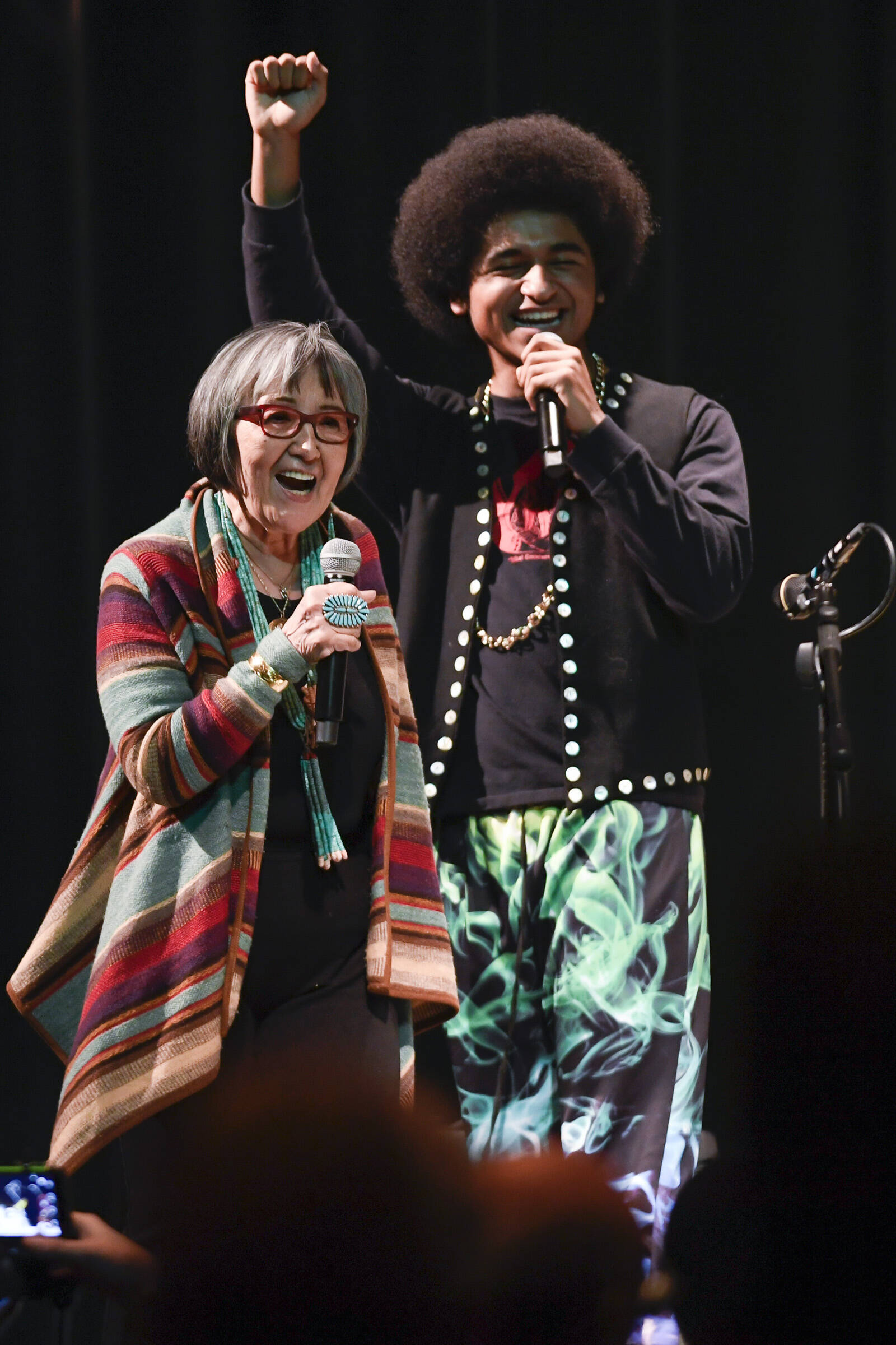 Rosita Worl, president of the Sealaska Heritage Institute, celebrates the performance of hip-hop duo of Arias “A.J.” Hoyle, right, and Chris Talley as an opening act before Khu.eex’ performance at Centennial Hall on Monday, Jan. 28, 2019. (Michael Penn / Juneau Empire File)