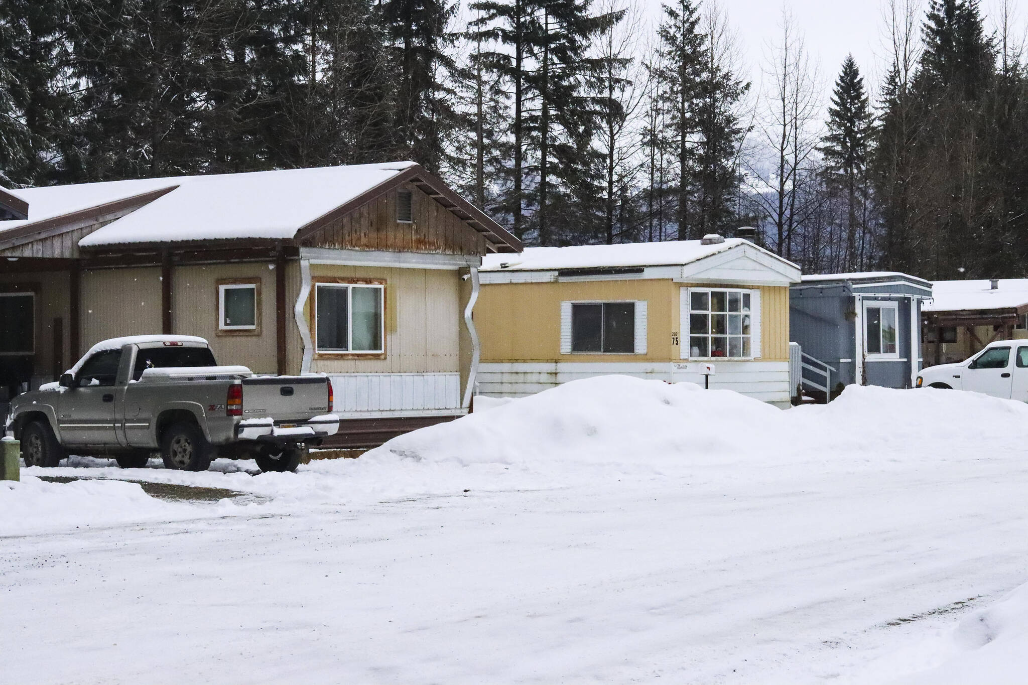 Juneau police officers hunkered down next to the berm visible between homes, said an eyewitness, before an officer fired his weapon three times and striking two trailers, mistakenly believing a man having a mental health crisis had a gun on Tuesday, Feb. 22, 2022. (Michael S. Lockett / Juneau Empire)