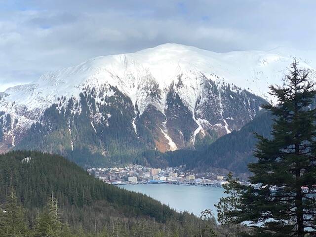 A sudden break in the cloud cover highlights the top of snow-capped Mount Juneau. (Courtesy Photo / Denise Carroll)
