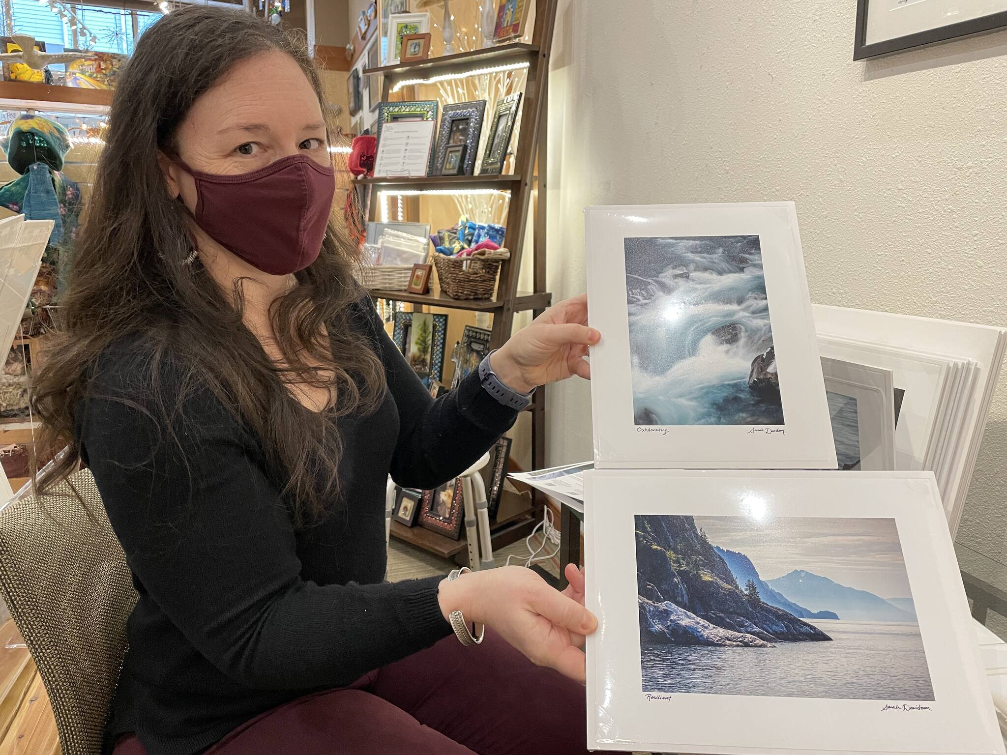 Michael S. Lockett / Capital City Weekly
Sarah Davidson, one of Annie Kaill’s featured artists for the March First Friday event, holds shots from her photography series “Moving Waters,” shot across Southeast Alaska using long-exposure photography.