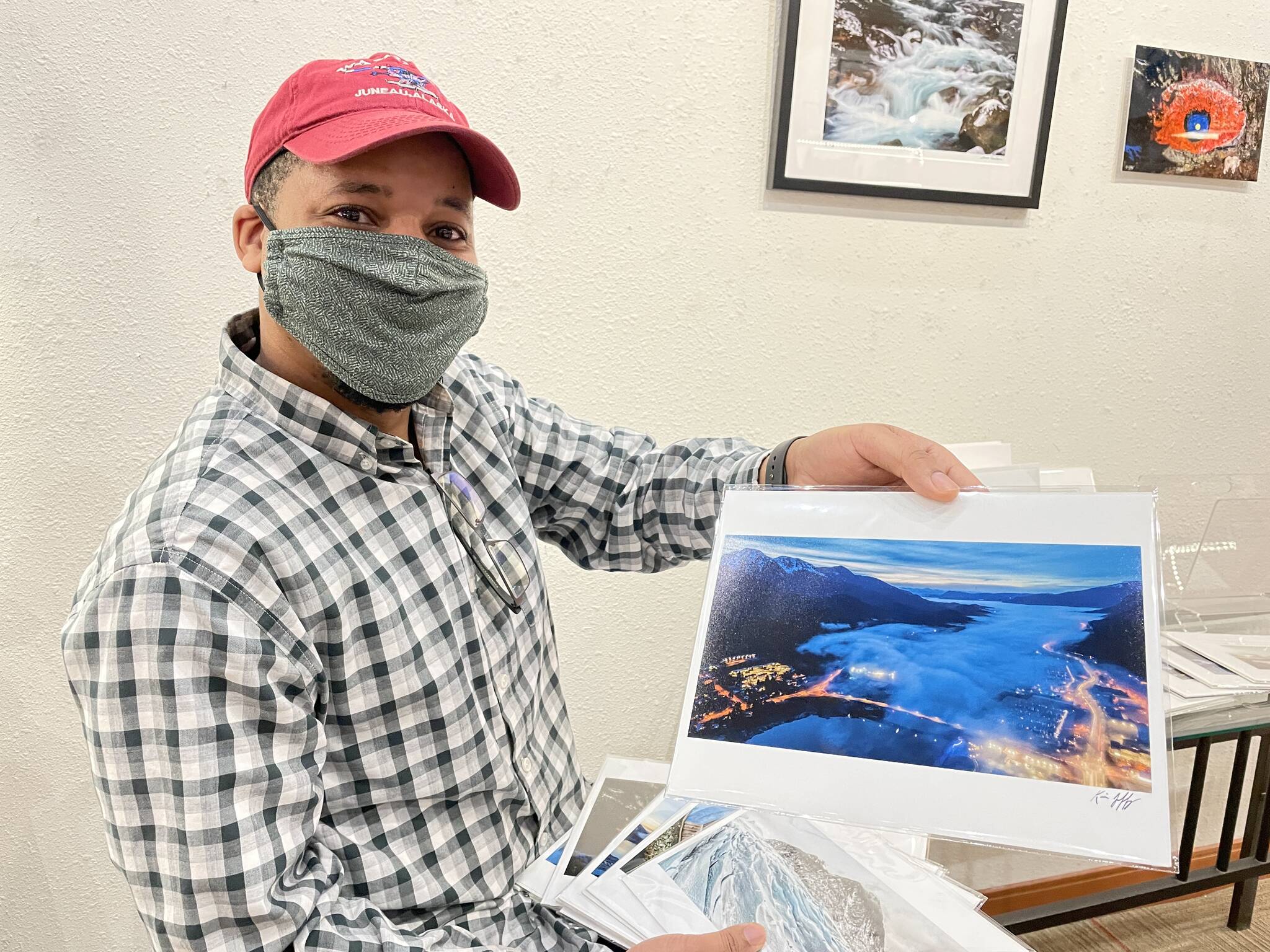 Kevin Jeffrey, one of Annie Kaill’s featured artists for the March First Friday event, holds a shot from his photography series “New Perspectives,” shot in Juneau using a drone. (Michael S. Lockett / Juneau Empire)